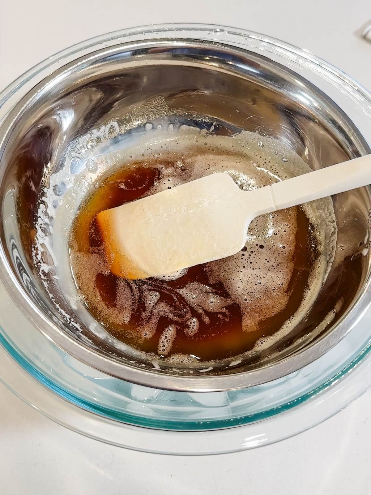 bowl of browned butter over a bowl of ice and water to cool the butter before making frosting.