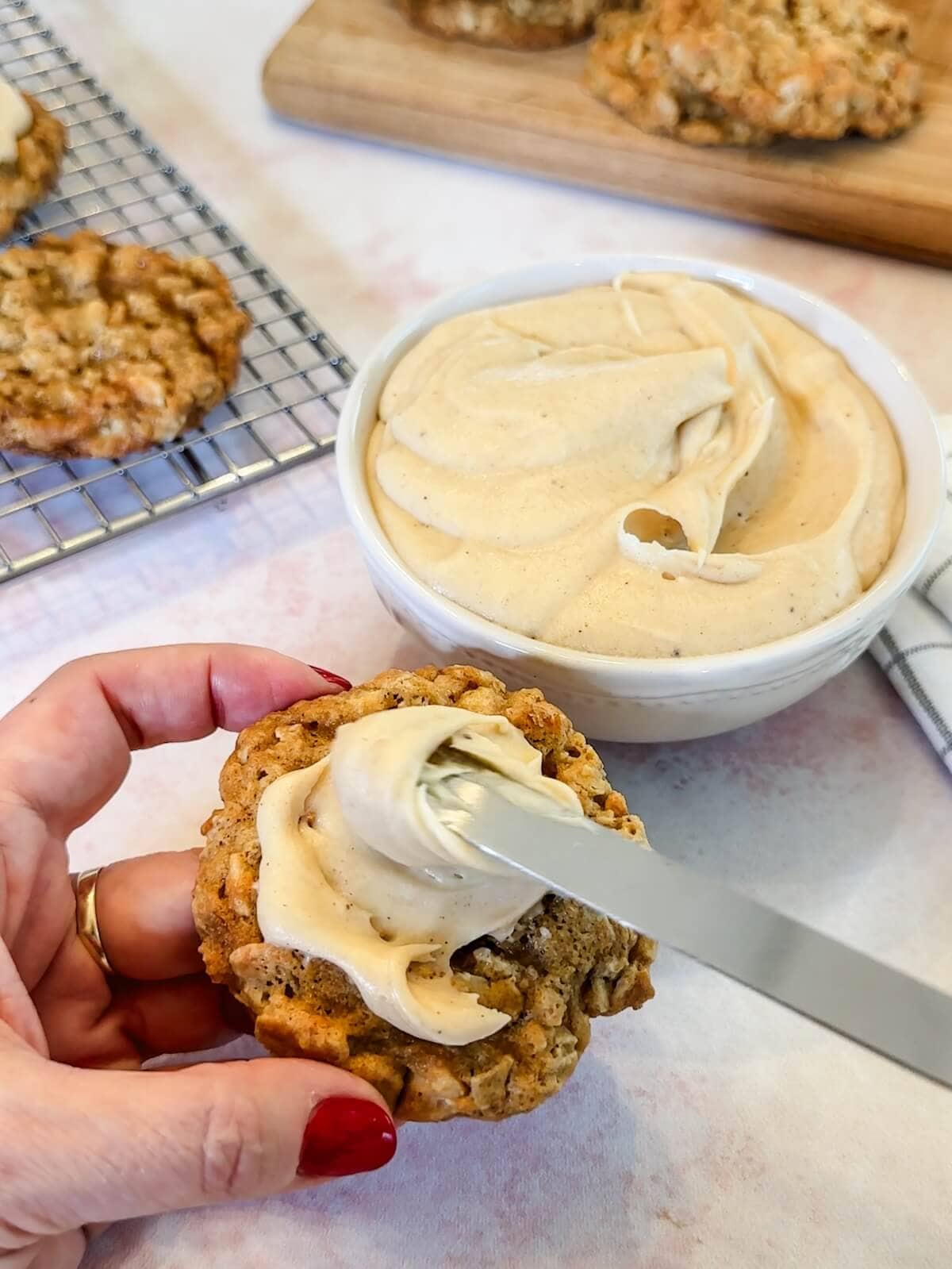 frosting oatmeal cashew cookies with browned butter frosting.