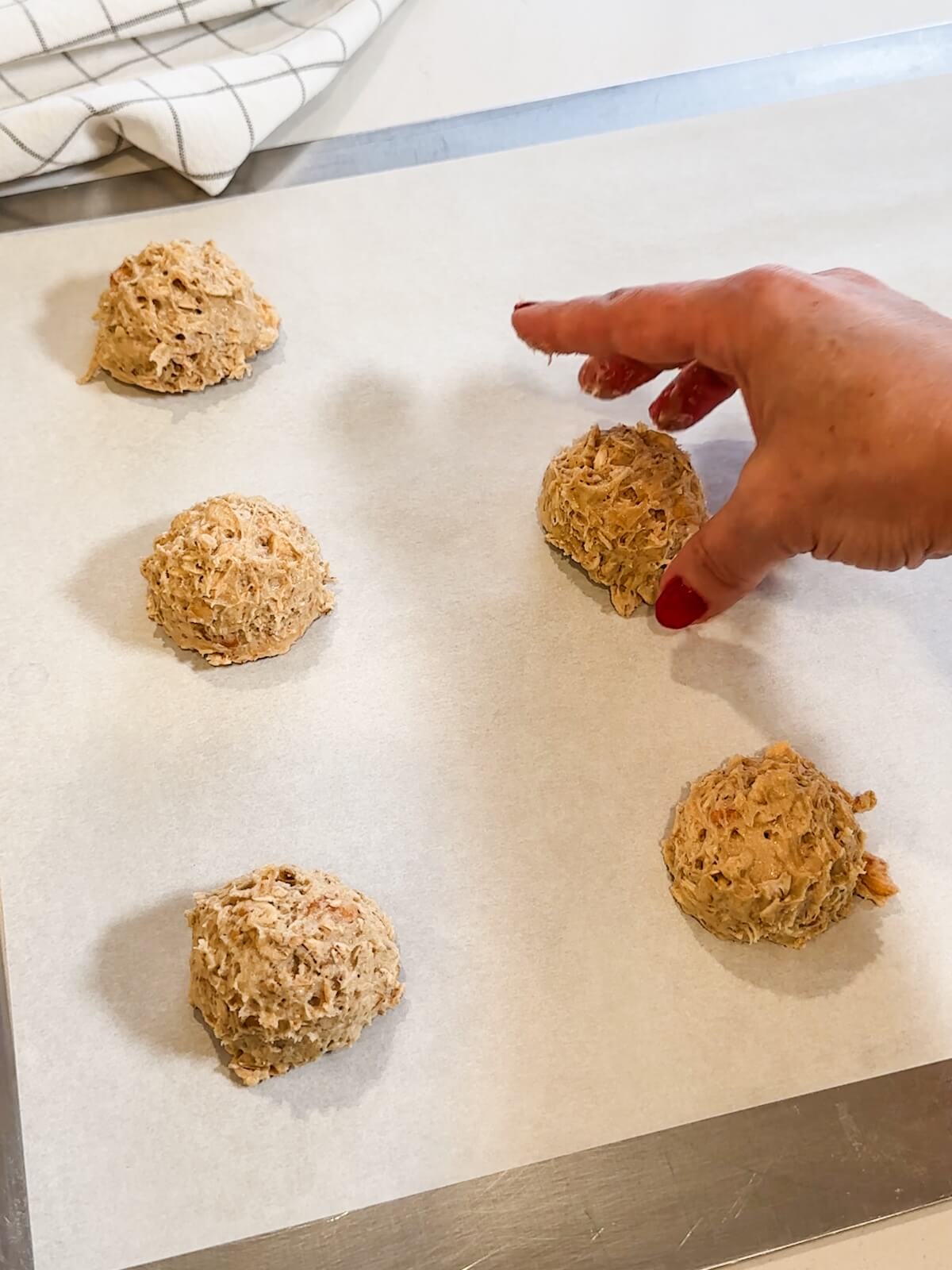 placing cookie dough balls on a baking sheet 2 inches apart.
