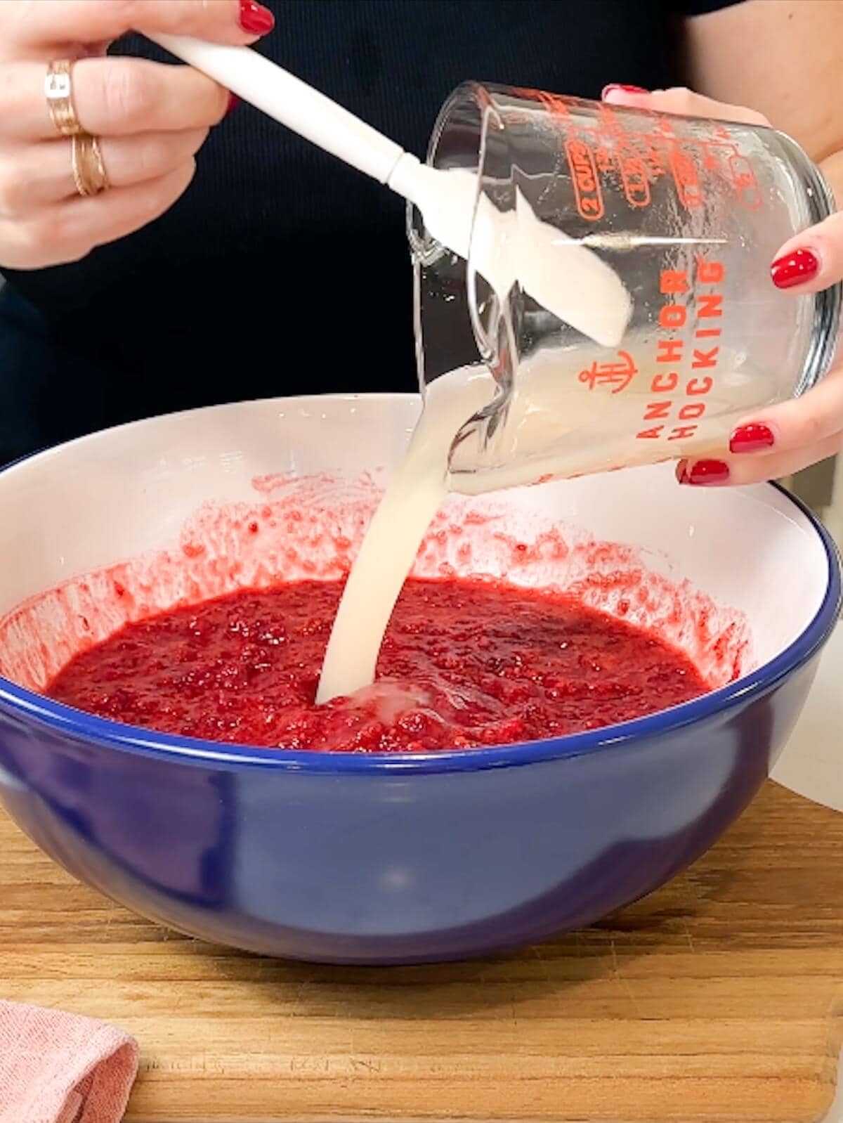 adding dissolved pectin mixture to raspberries.