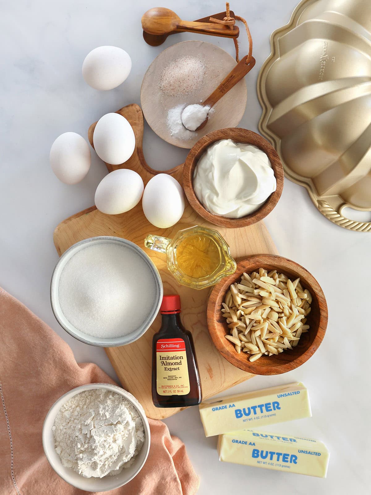 Ingredients needed to make an almond pound cake laid out on a counter.