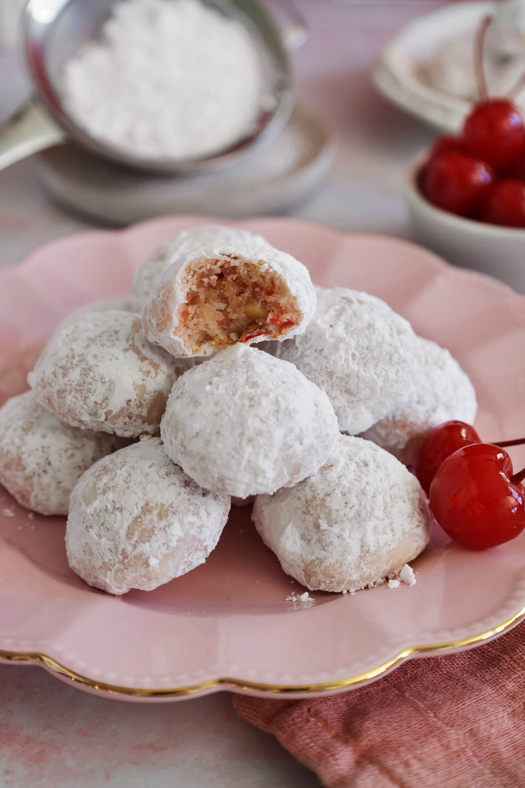 Close up of cherry almond cookies with a bite taken out of the top cookie.