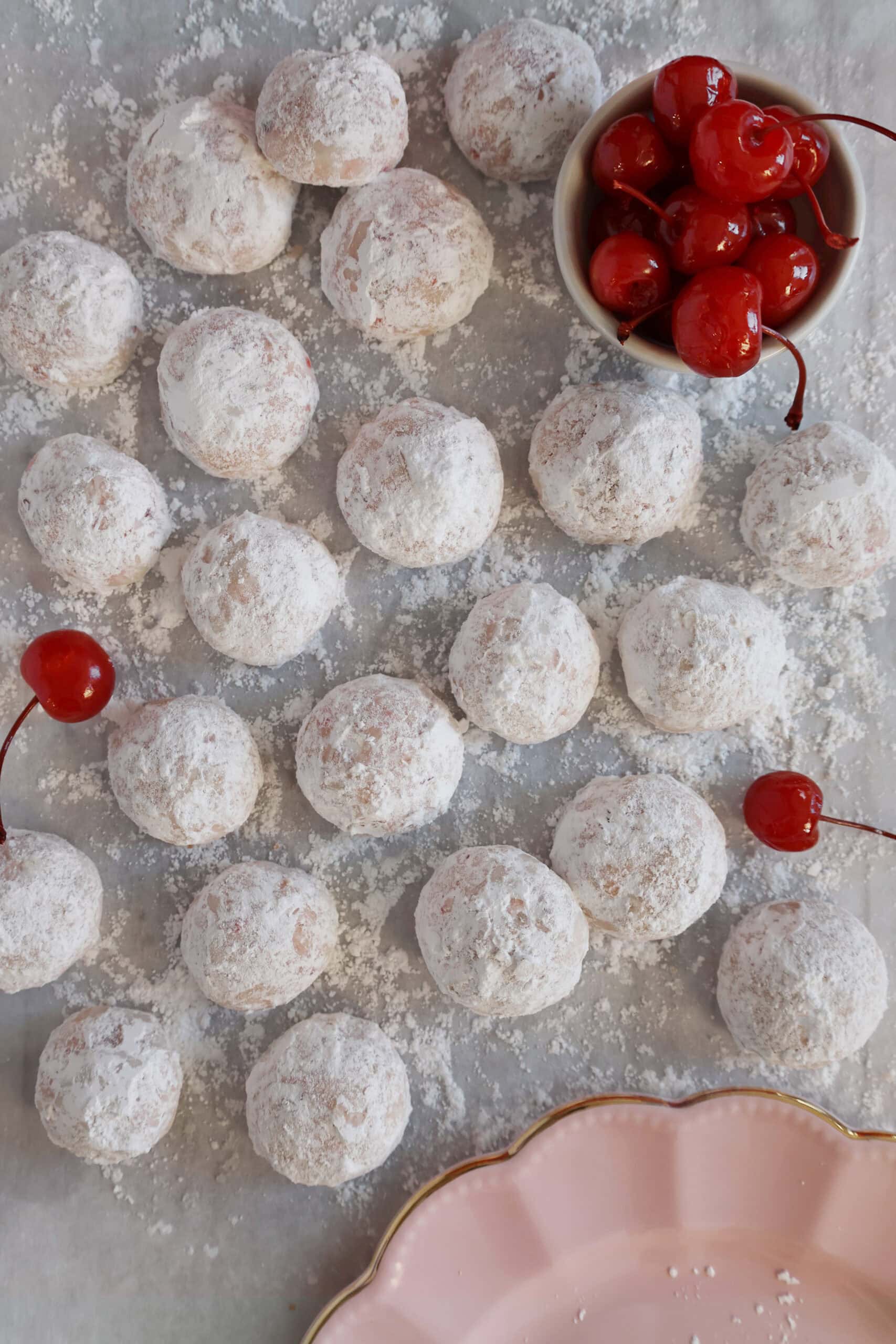 Overhead view of cherry almond cookies dusted with powdered sugar.
