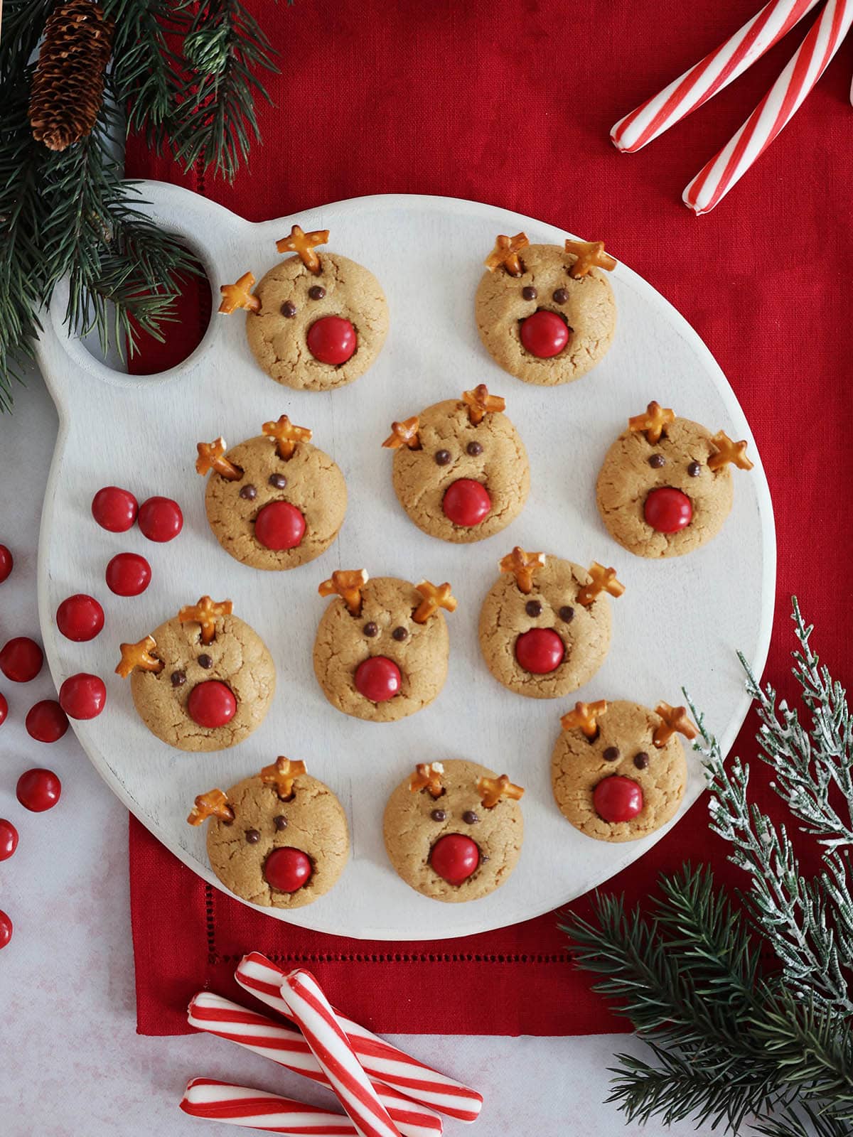 Top view of a cutting board covered with Rudolph reindeer cookies.