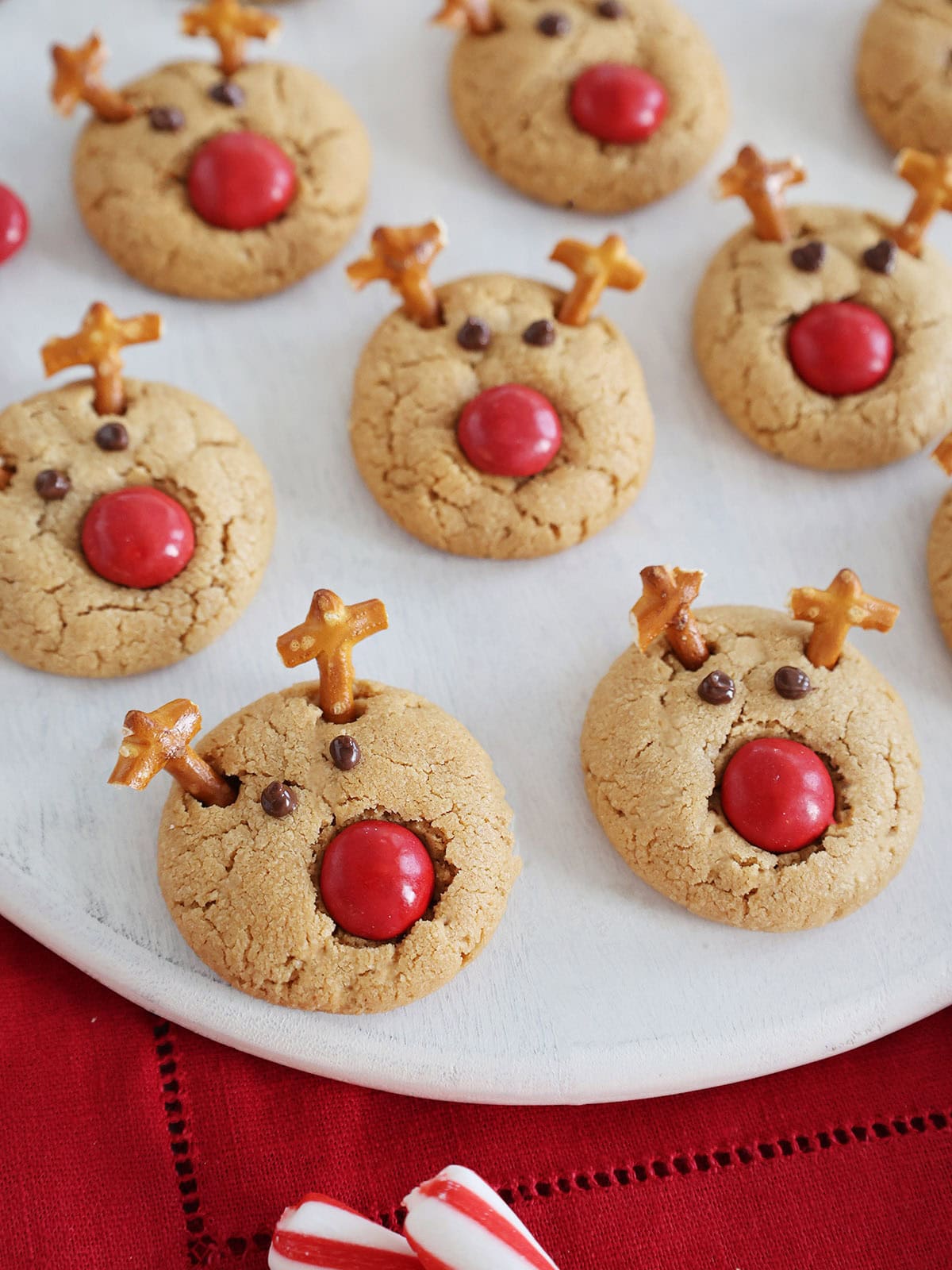 Rudolph reindeer cookies on a white cutting board.