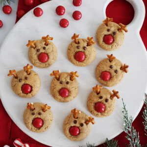Top view of a cutting board covered with Rudolph reindeer cookies.