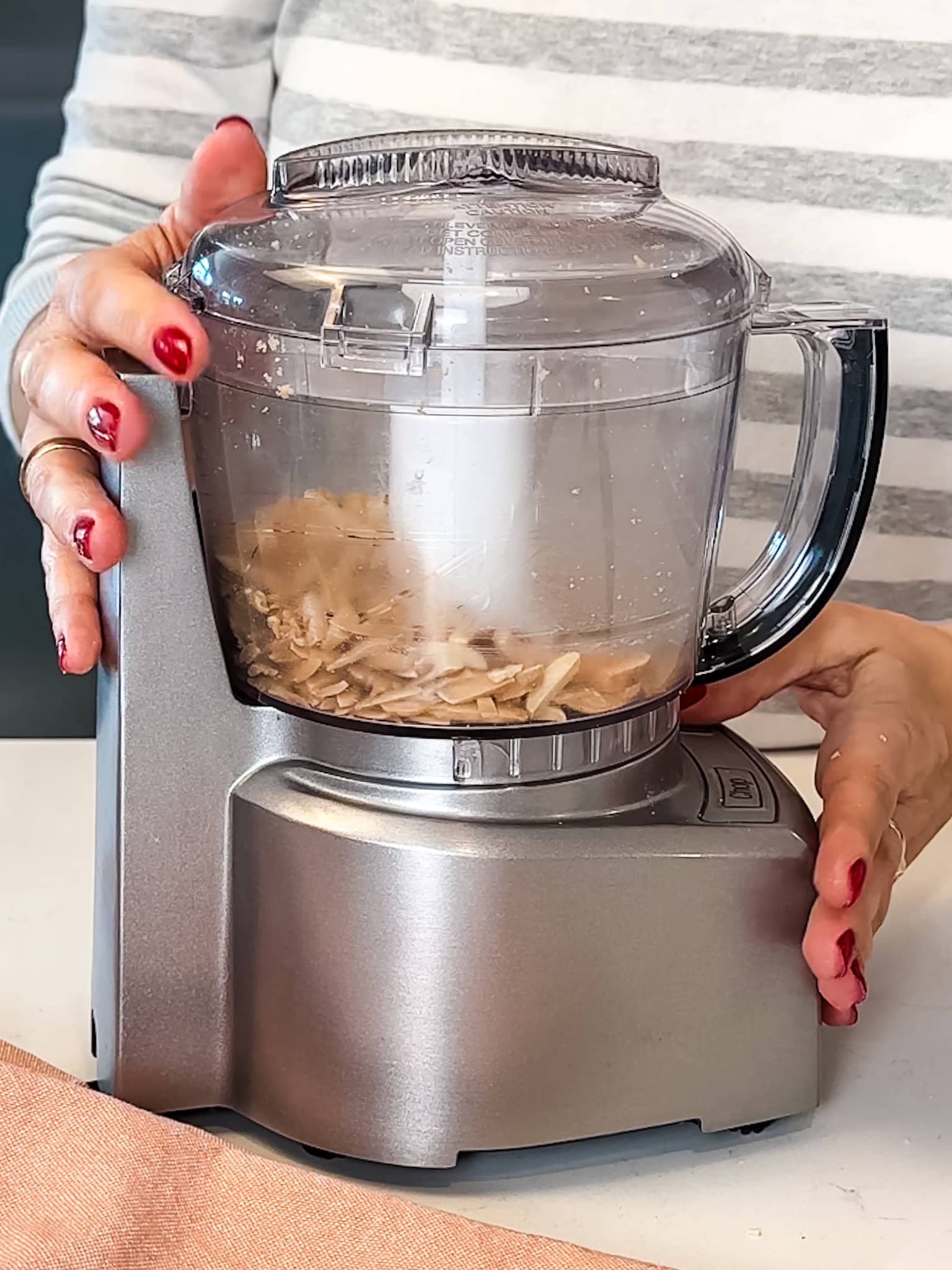 Slivered almonds being processed in a food processor.