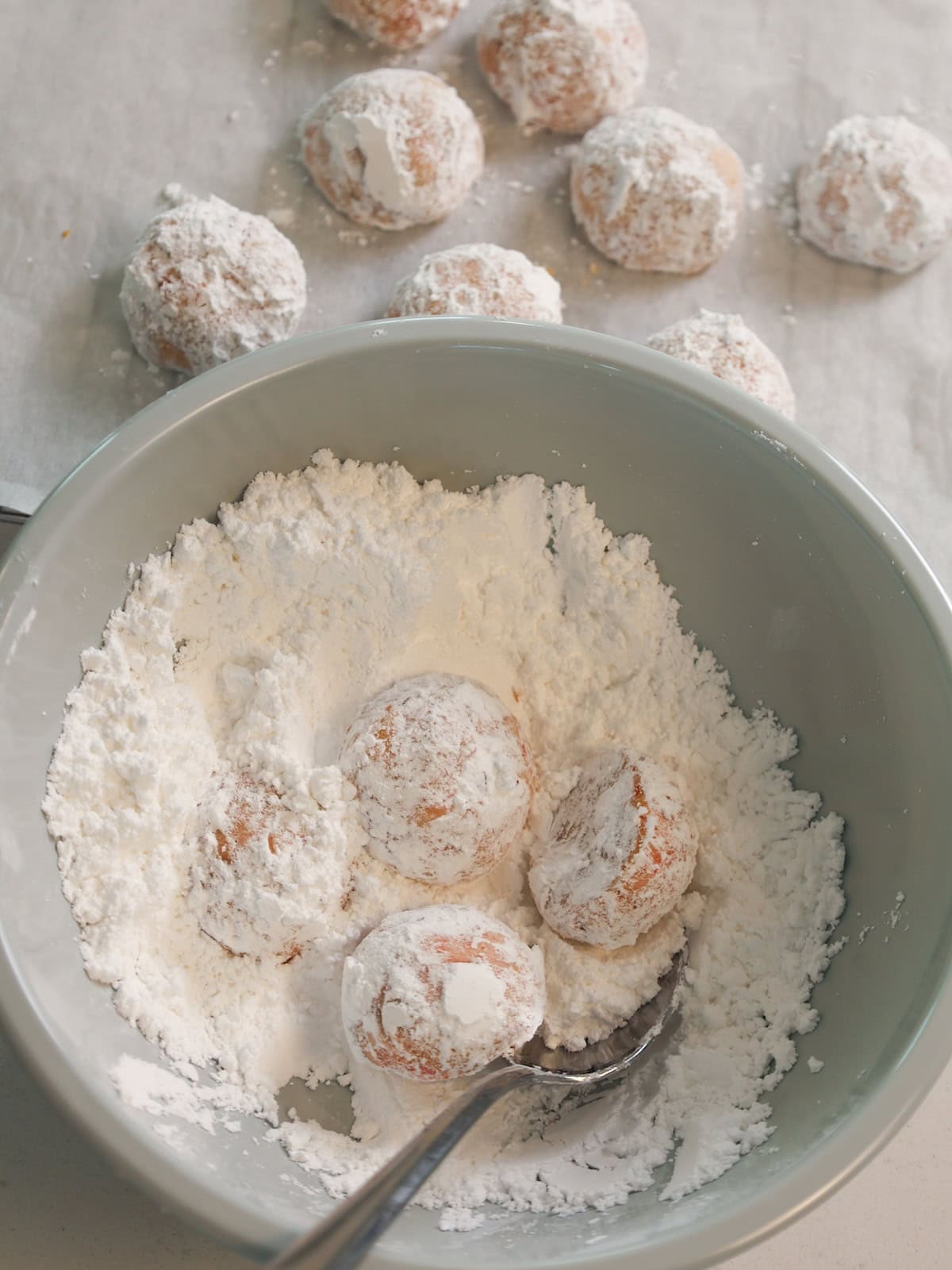 Cherry almond cookies being covered with confectioners' sugar.