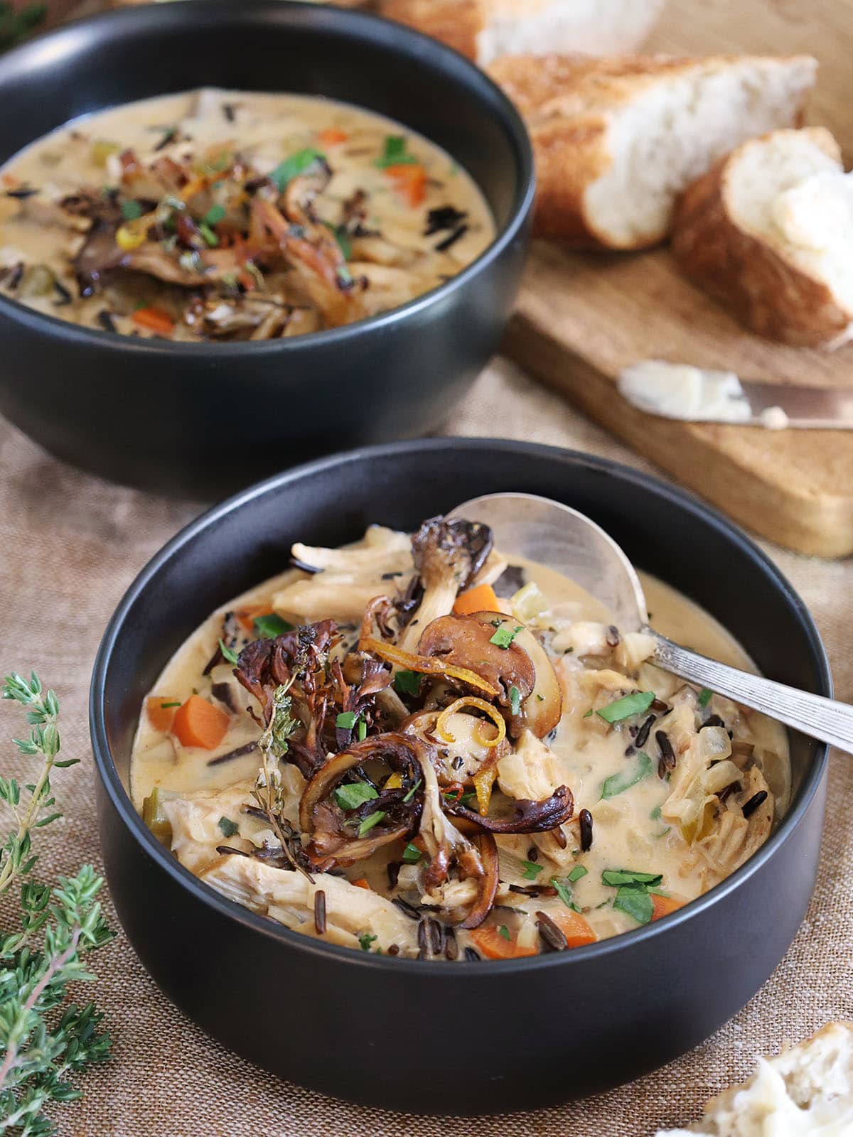 Close up of a bowl of chicken mushroom soup topped with crisped mushrooms.