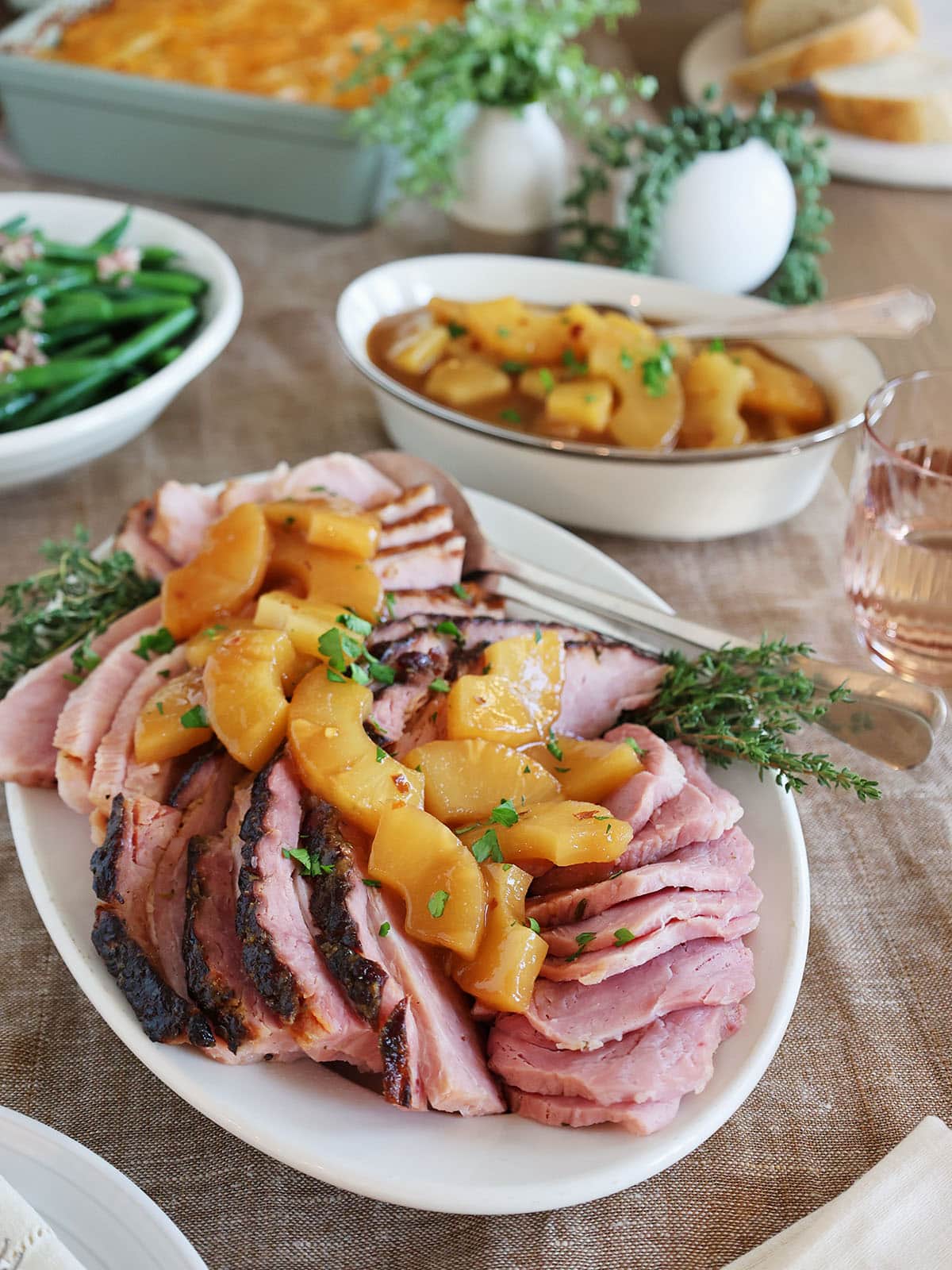 A platter topped with sliced ham and pineapple sauce.