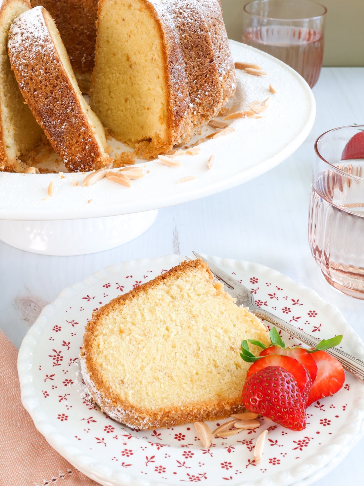 close up of a slice of cake with strawberries on a plate.
