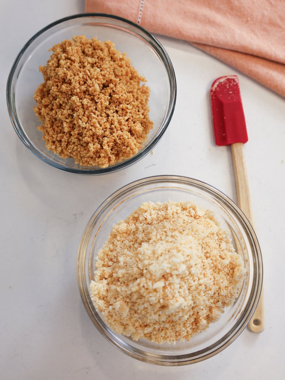 Top view of two bowls: one filled with ground almonds, the other filled with a ground almond sugar mixture.