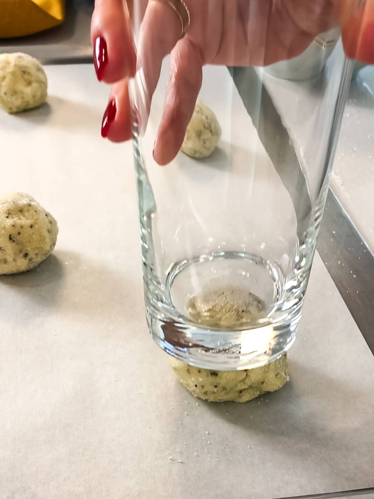 partially flattening cookie dough balls with the bottom of a glass.