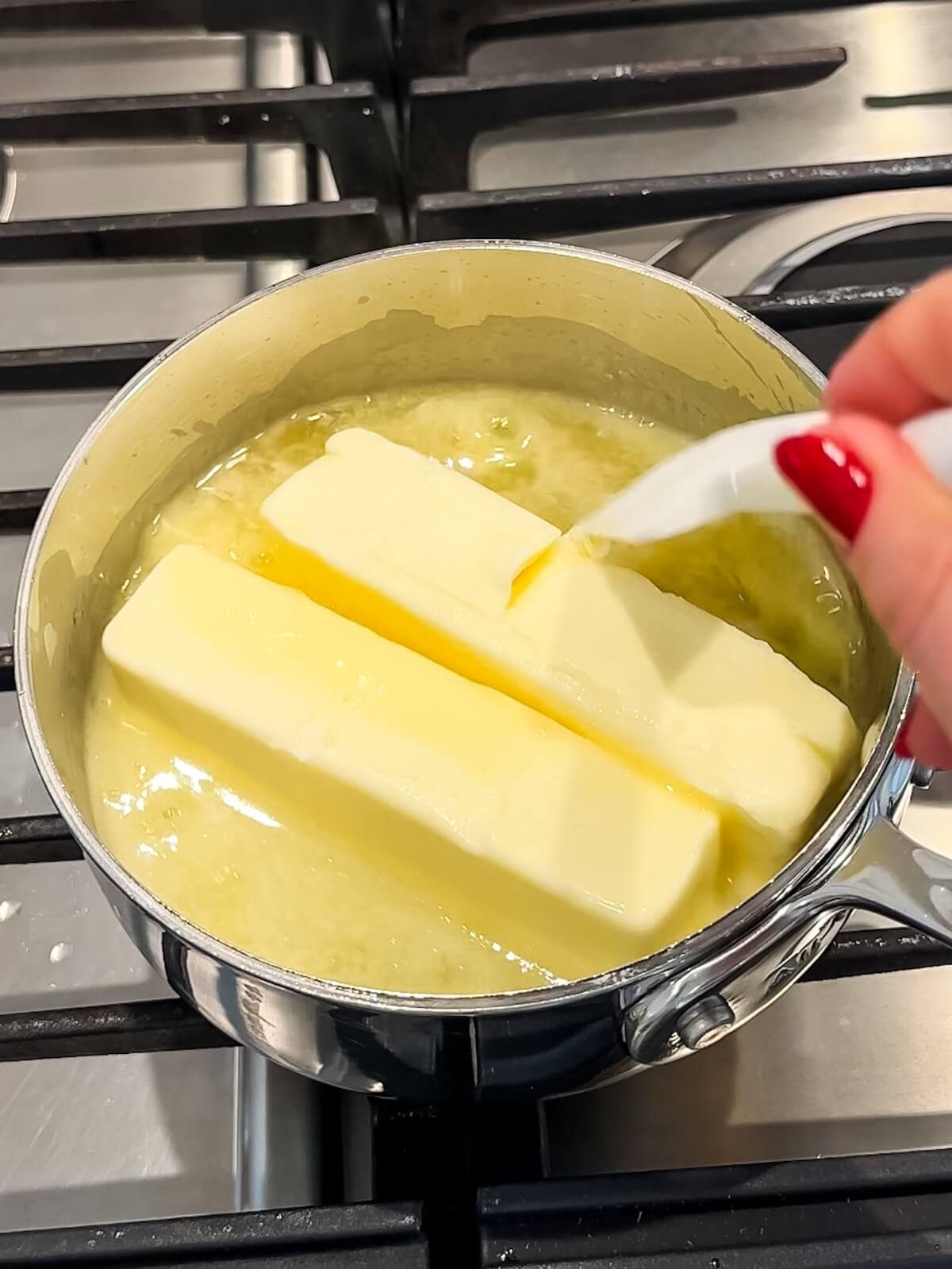 melting butter with lemon juice in a saucepan on the stove.
