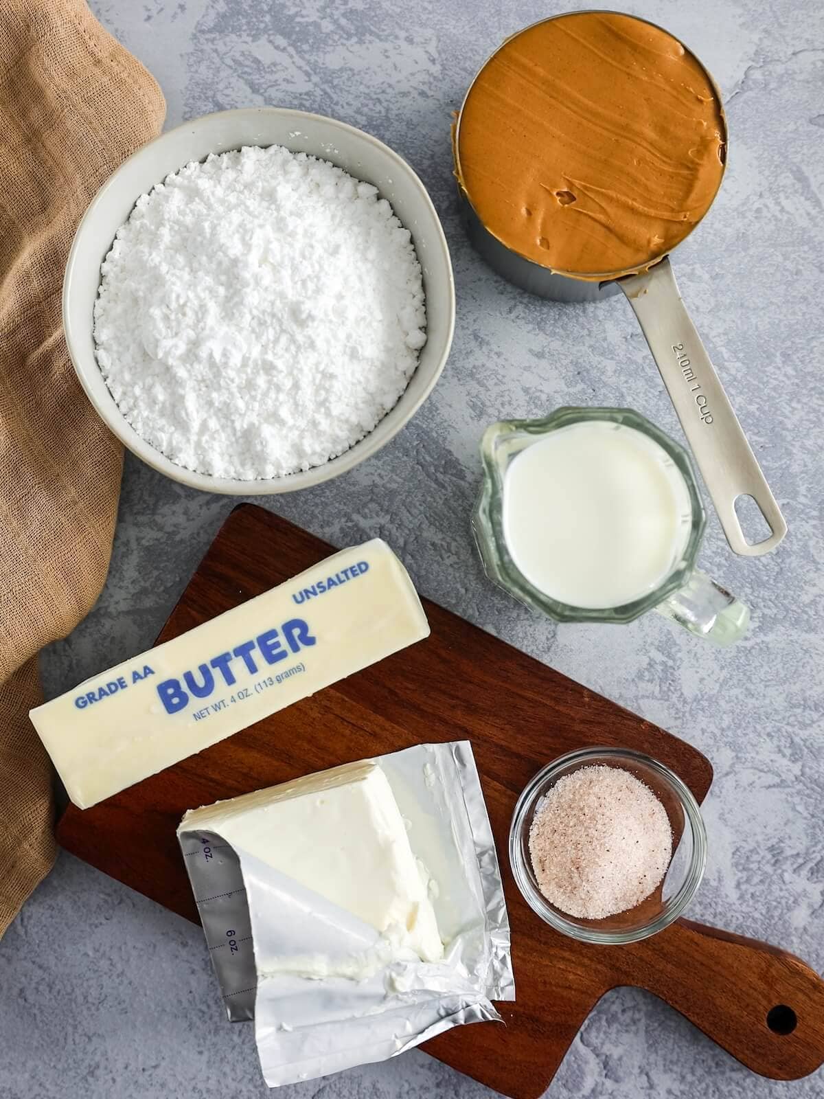 Ingredients for peanut butter frosting including smooth peanut butter, confectioners' sugar, butter, milk, salt, and cream cheese.