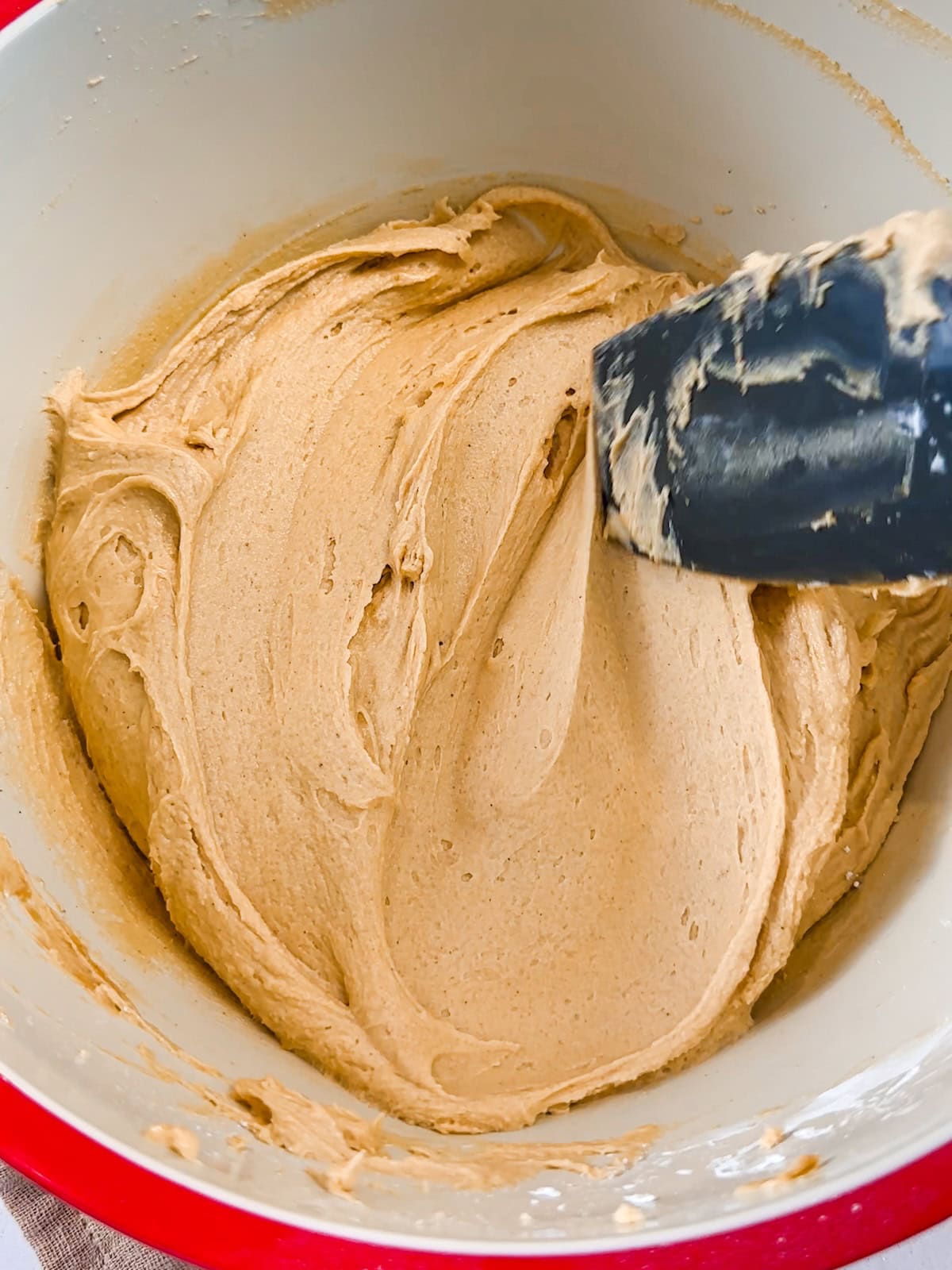 Smooth and fluffy peanut butter frosting in a bowl.