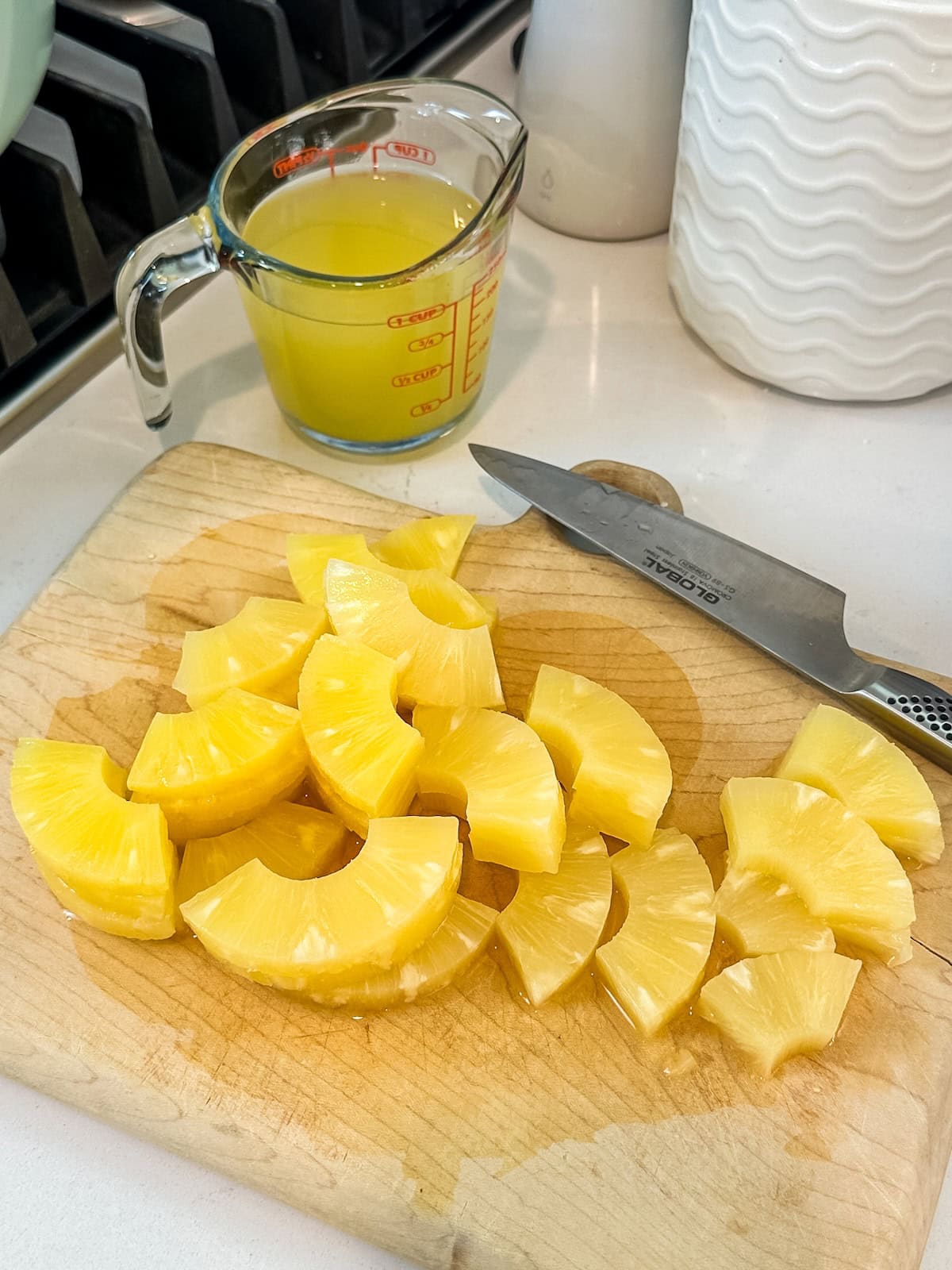 Cutting up canned pineapple for sauce.