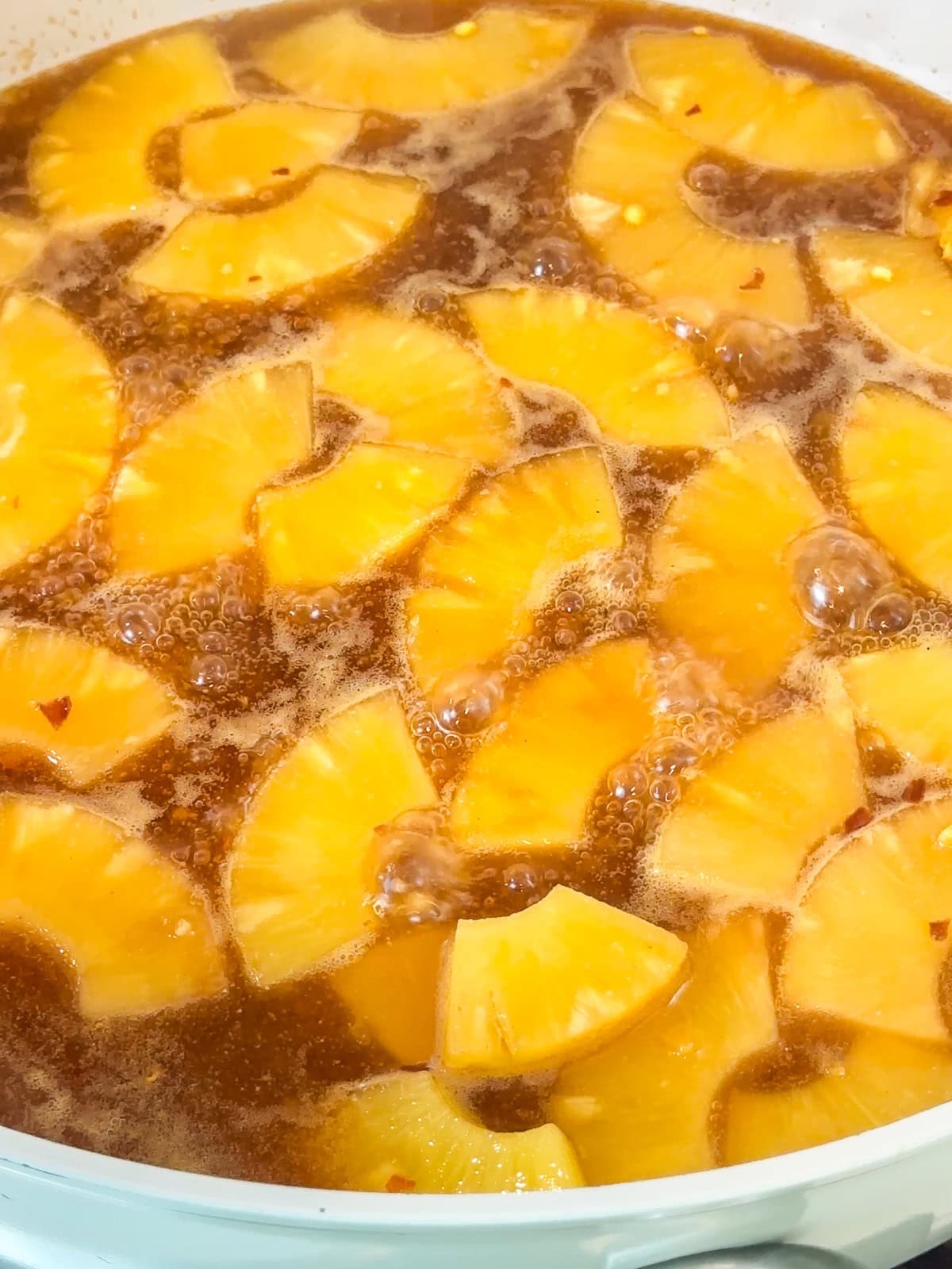 Simmer pineapple sauce until it has thickened and bubbling.