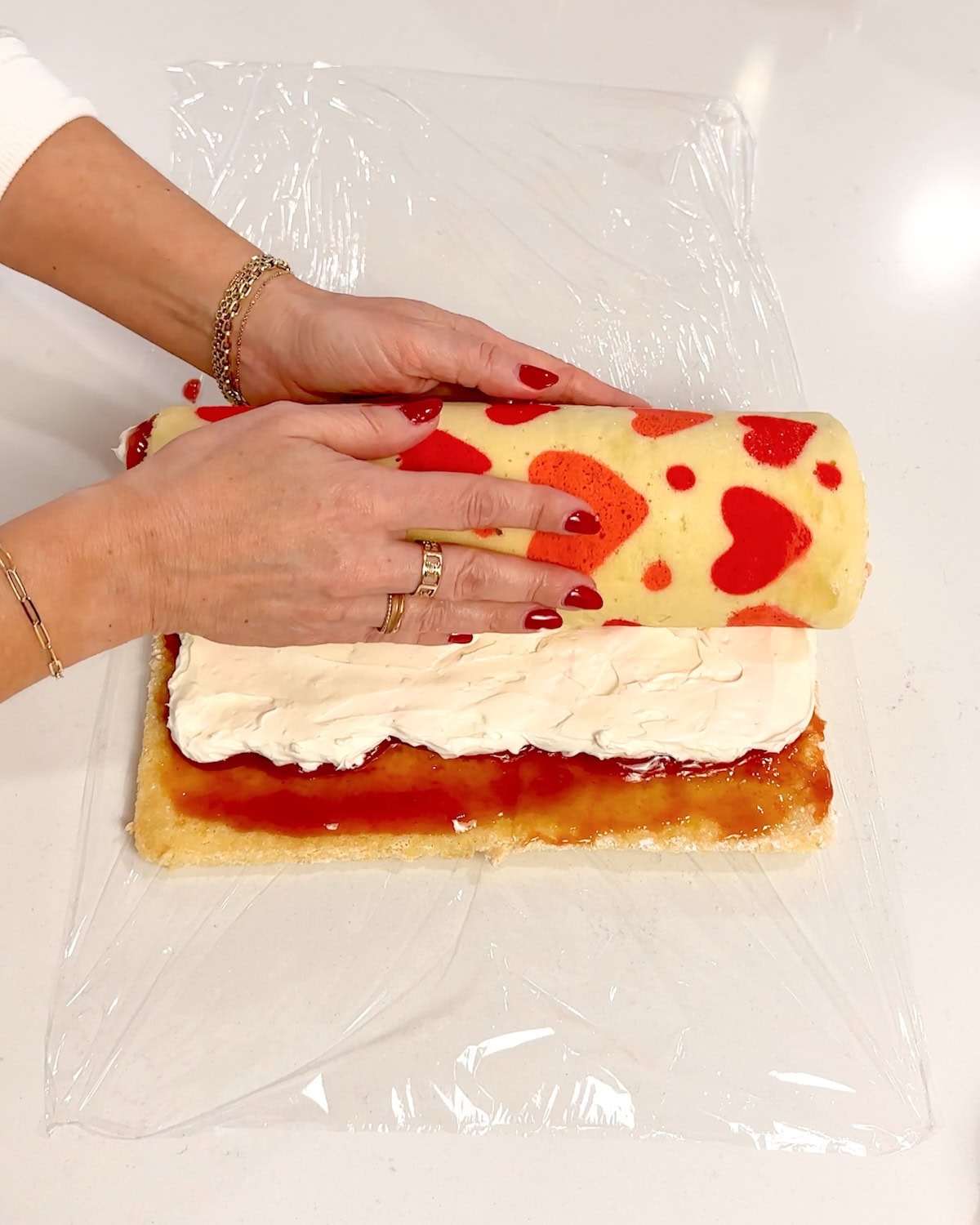 gently rolling cake into a log over the fluffy filling.