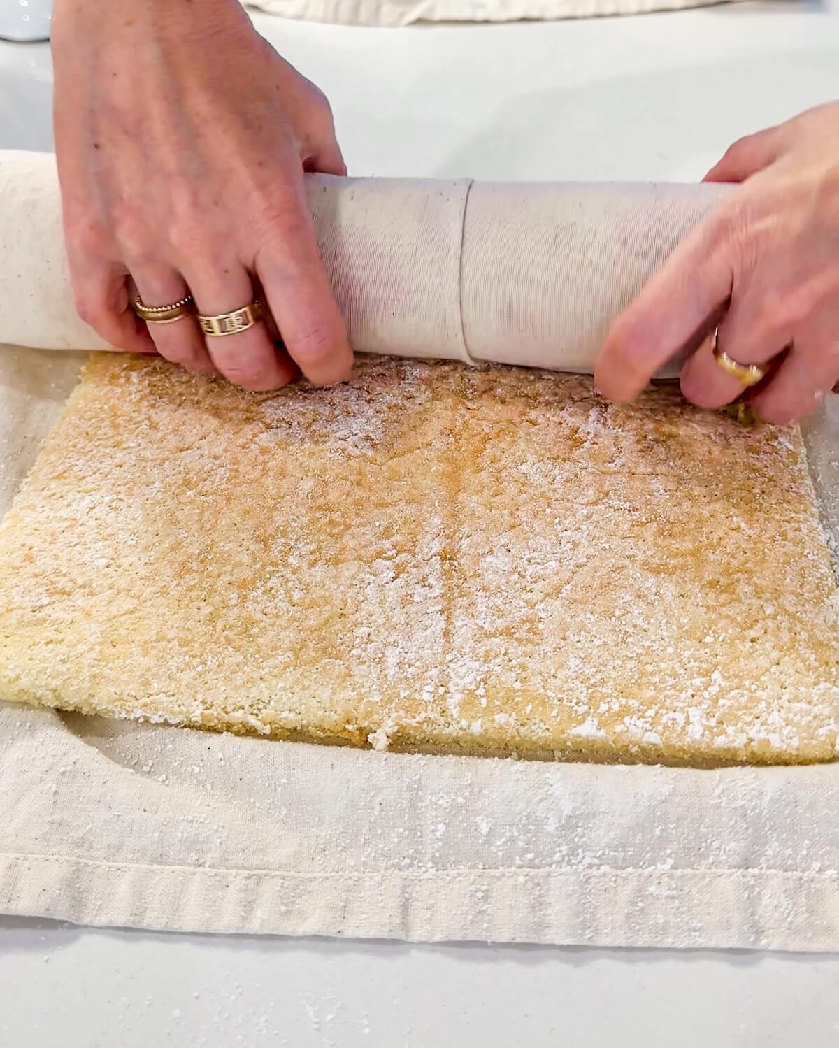 gently rolling cake in a towel to cool in a roll shape.