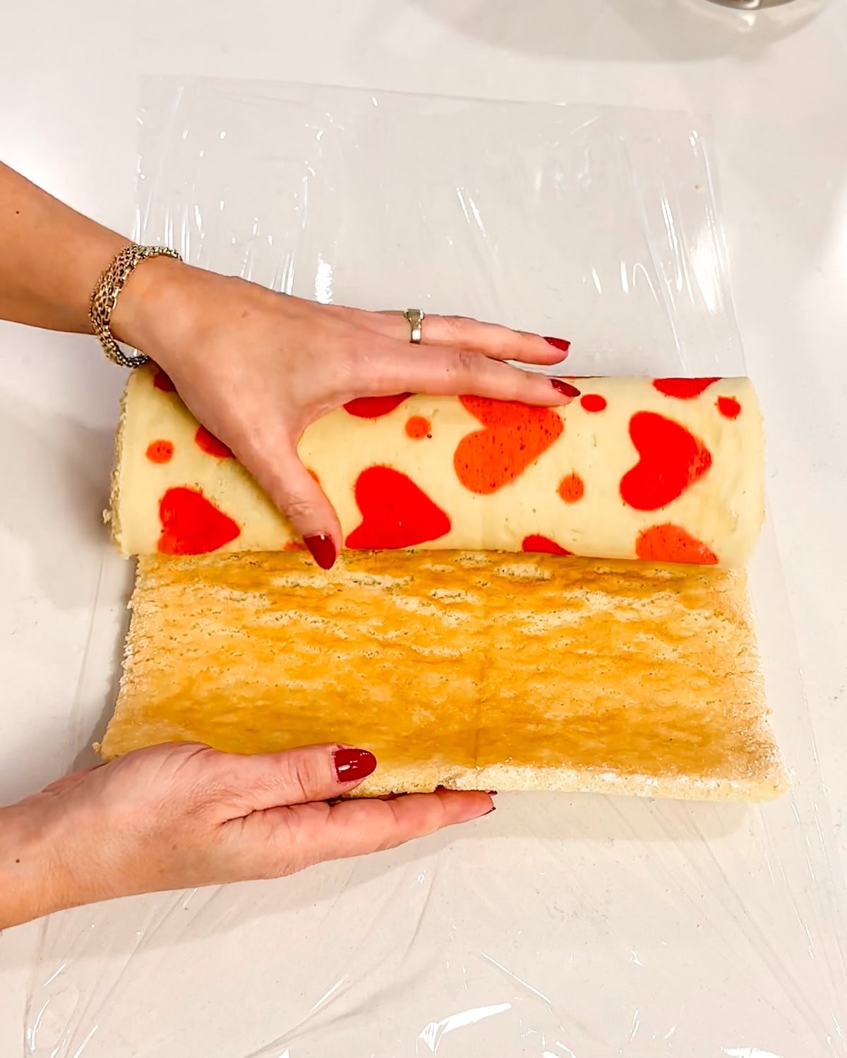 unrolling cooled cake onto plastic wrap.