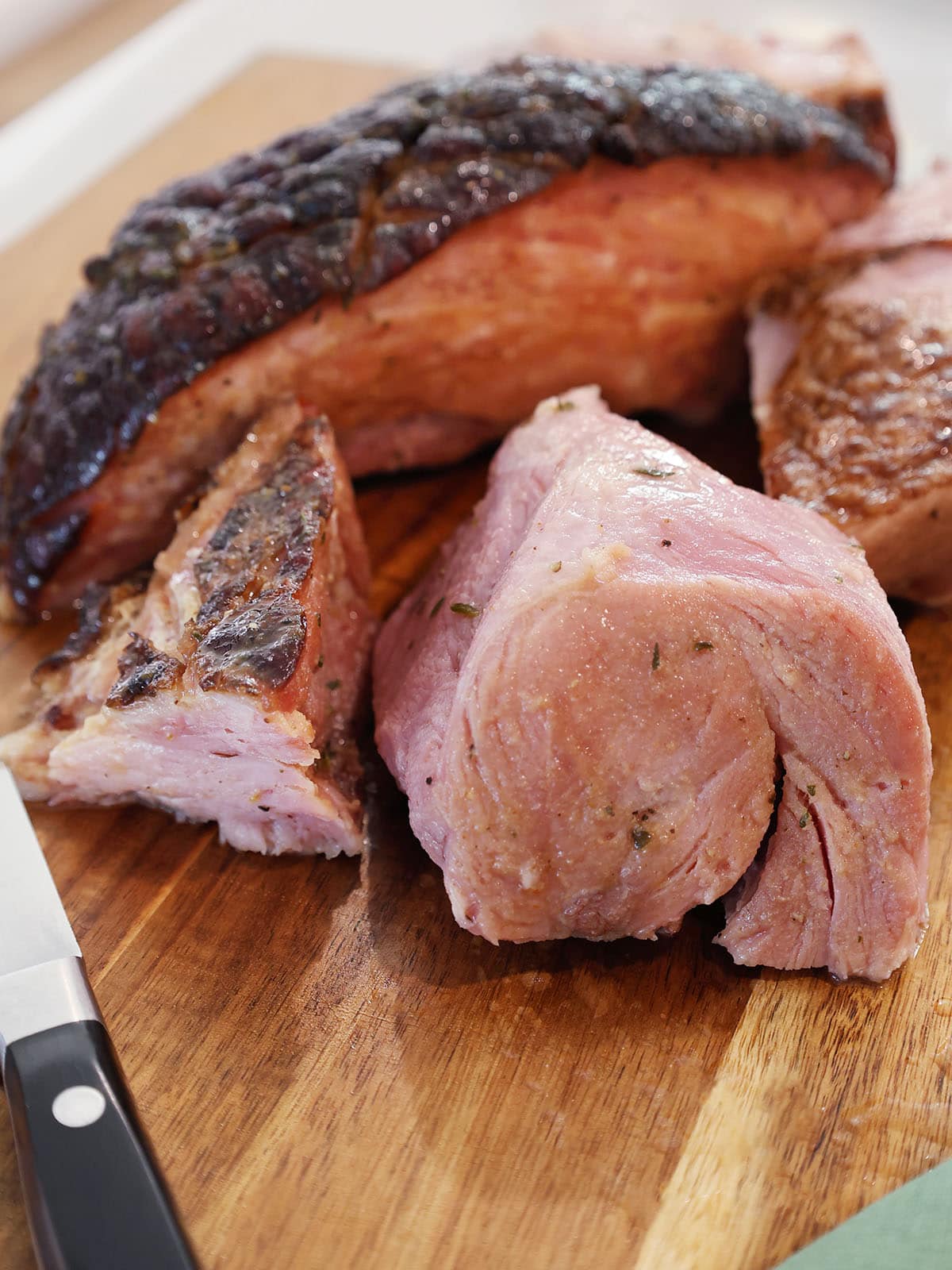 Large chunks of roasted ham on a cutting board.