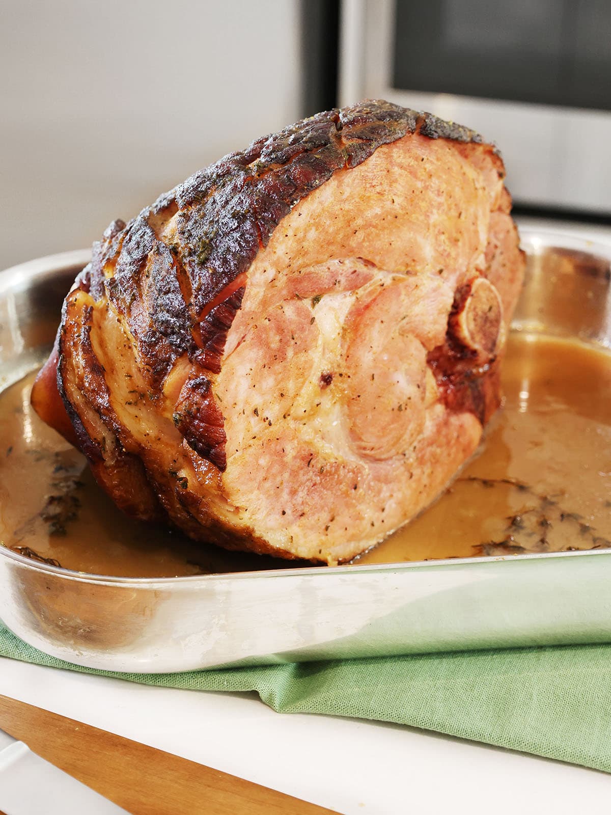 Fully baked pineapple roasted ham in a roasting pan.