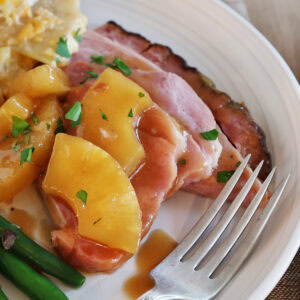 Close up of a serving of pineapple roasted ham topped with pineapple slices.