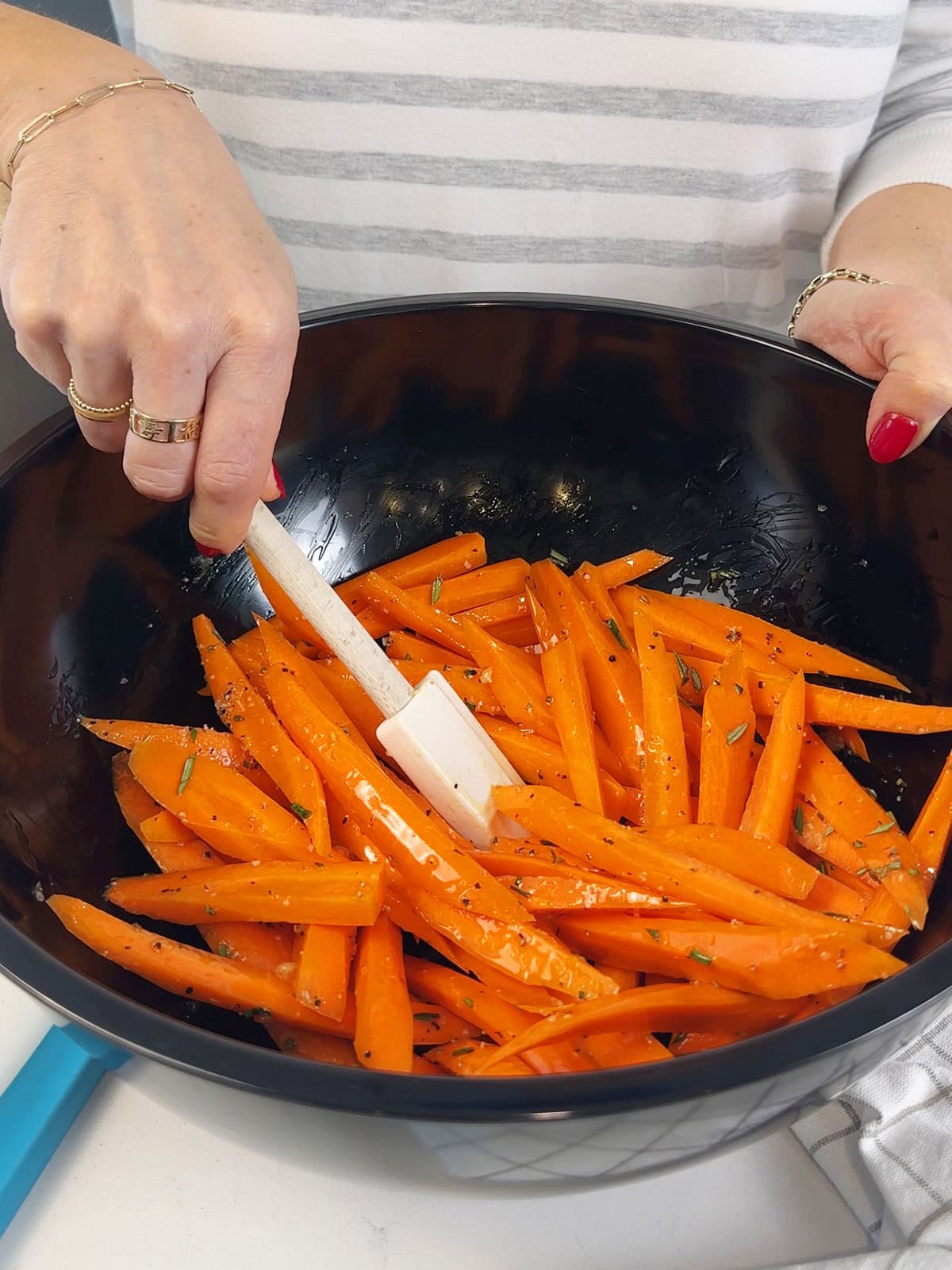 Stirring carrots with seasonings for roasted carrots.