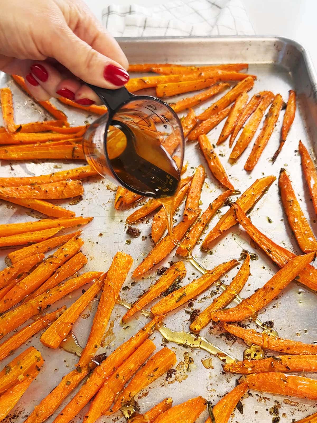 Drizzling honey over roasted carrots