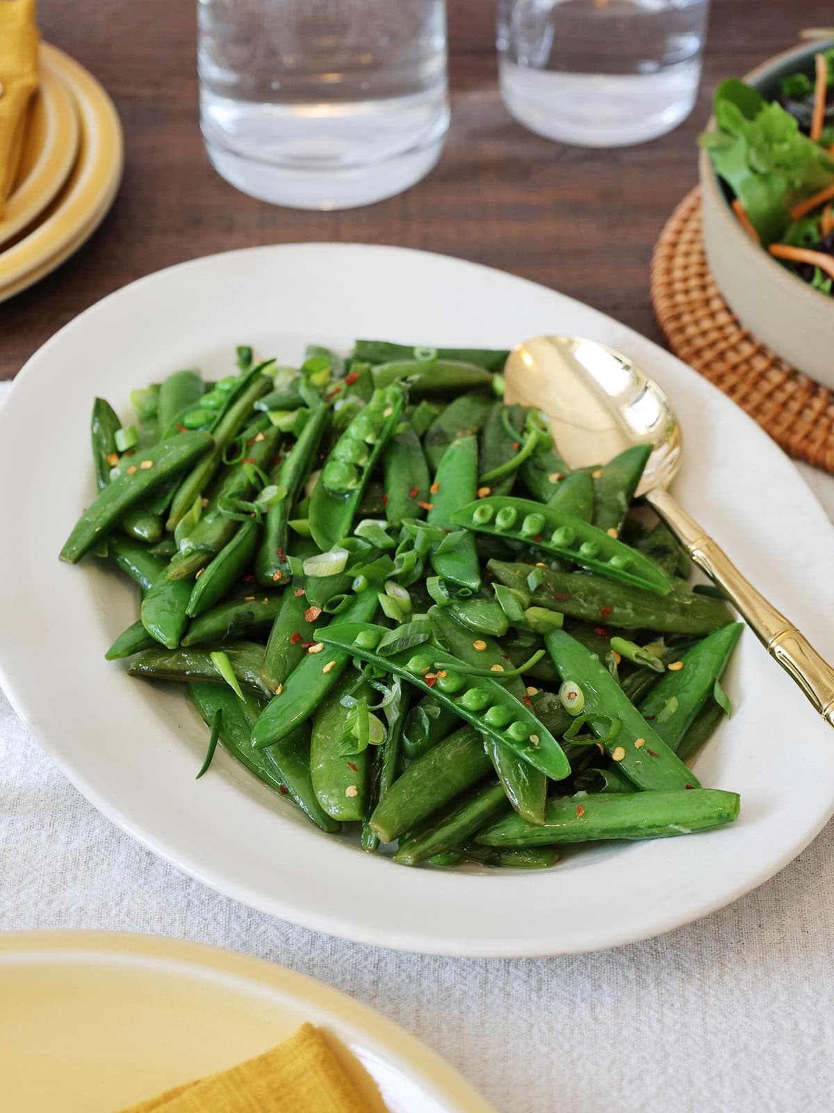 A serving dish filled with sauteed sugar snap peas.