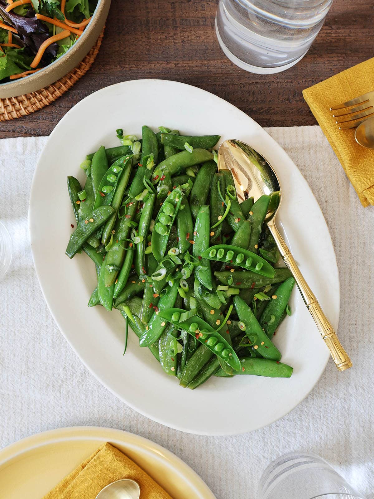 Overhead view of a serving dish filled with sauteed sugar snap peas.