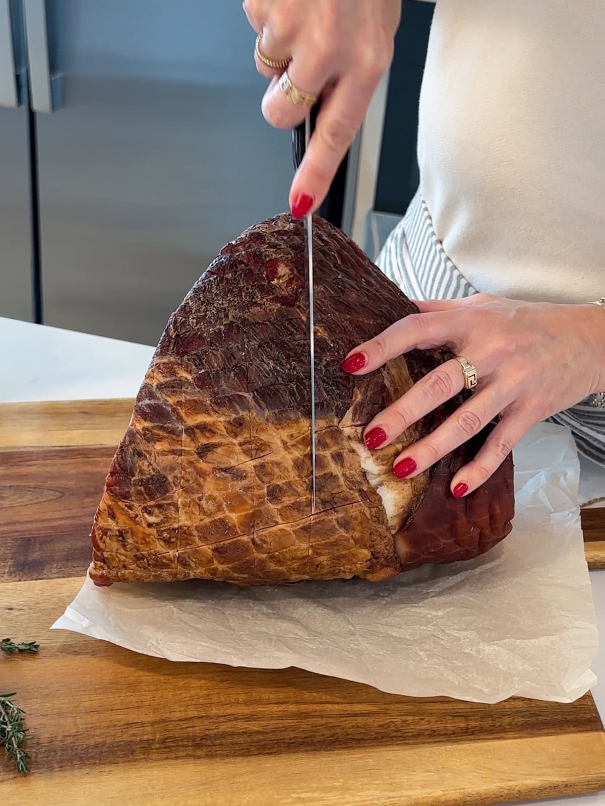 Cutting crosshatch pattern on the outside of a whole ham before roasting.
