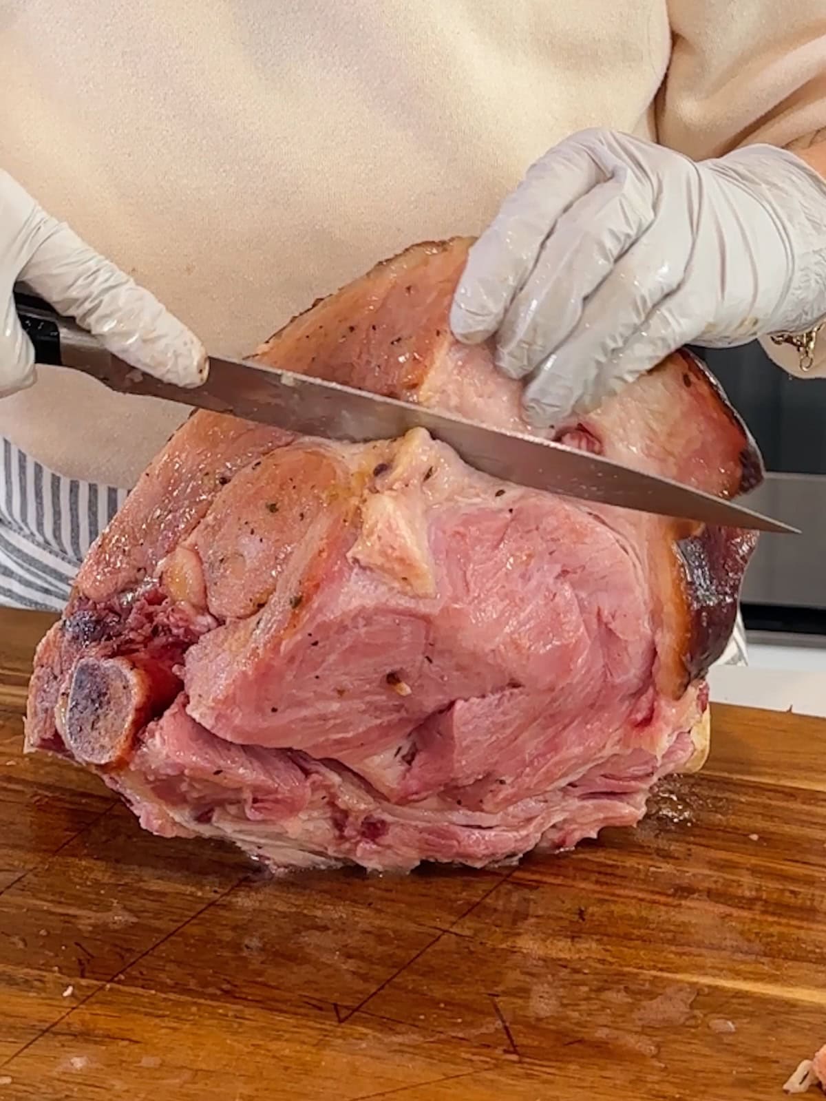 Cutting sections off a roast ham to slice and serve.