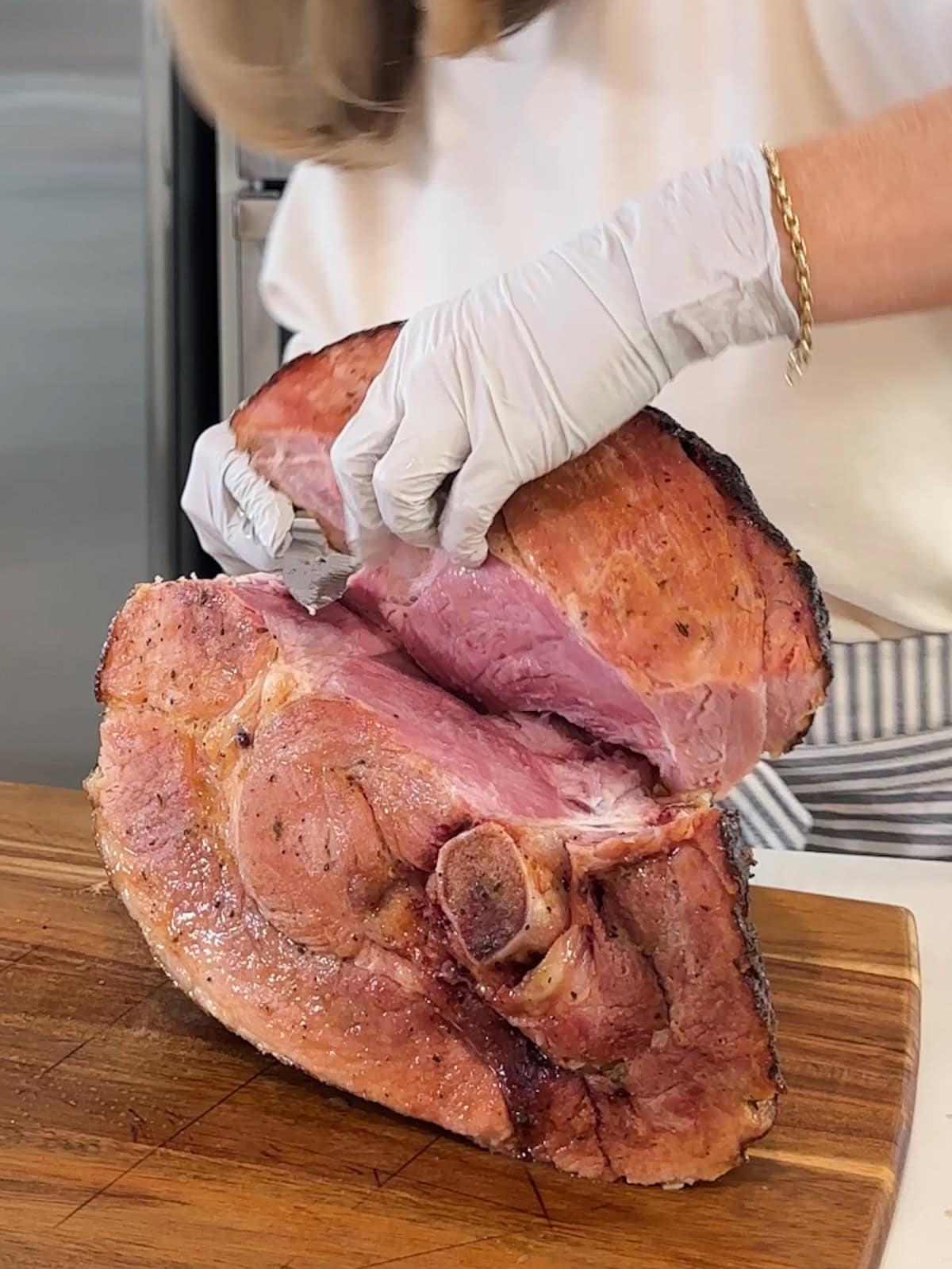 Cutting a section off pineapple roast ham for slicing and serving.