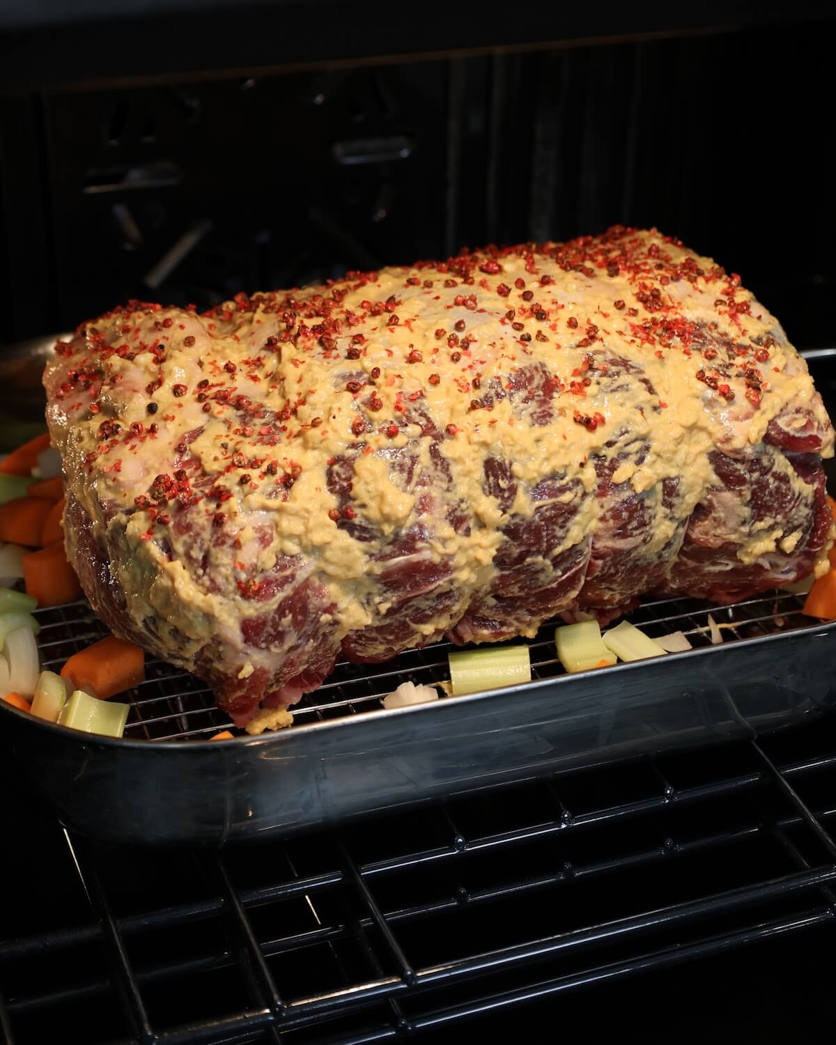 A prime rib roast in pan in an oven.