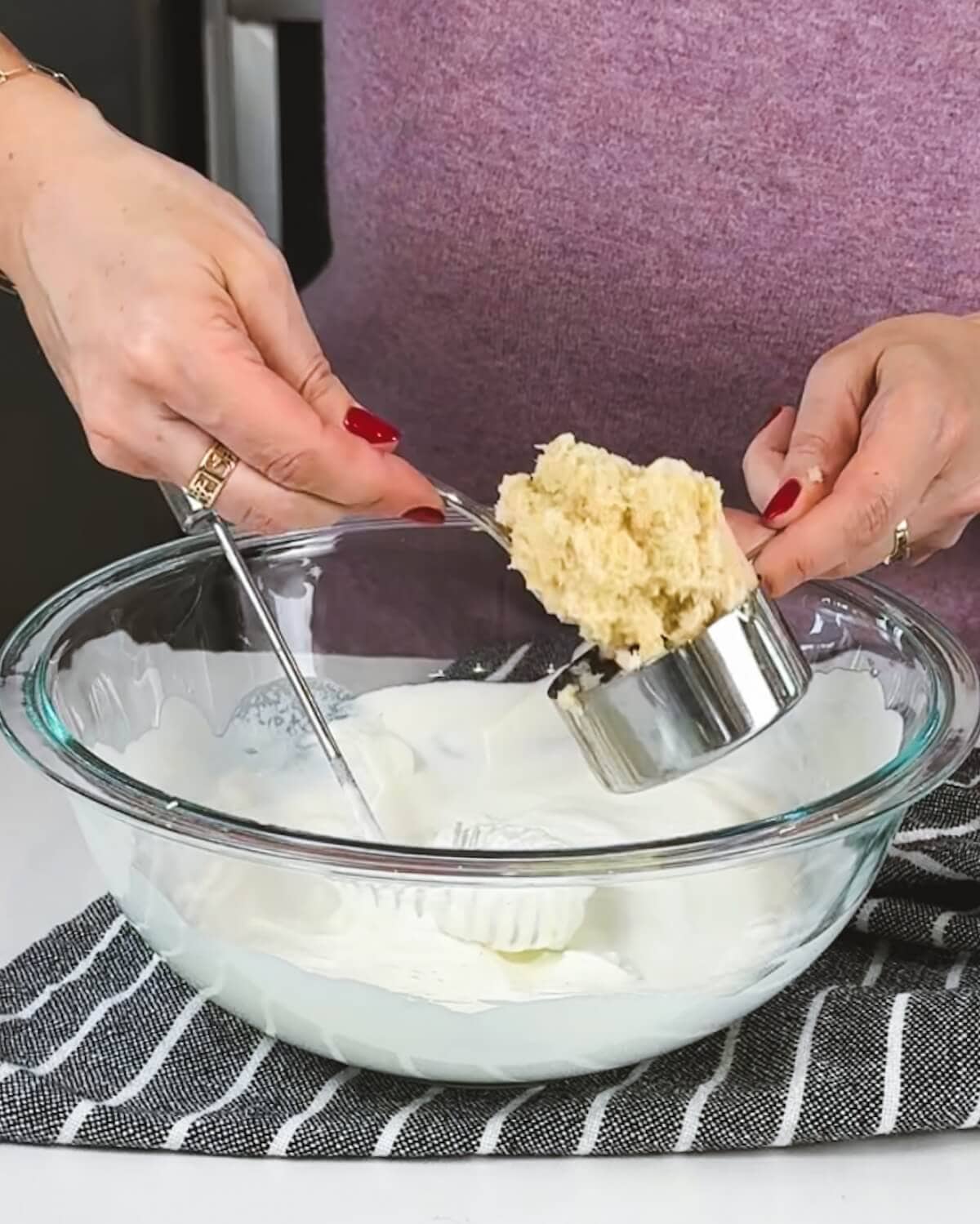 Adding prepared horseradish to whipped cream to make creamy sauce for prime rib.