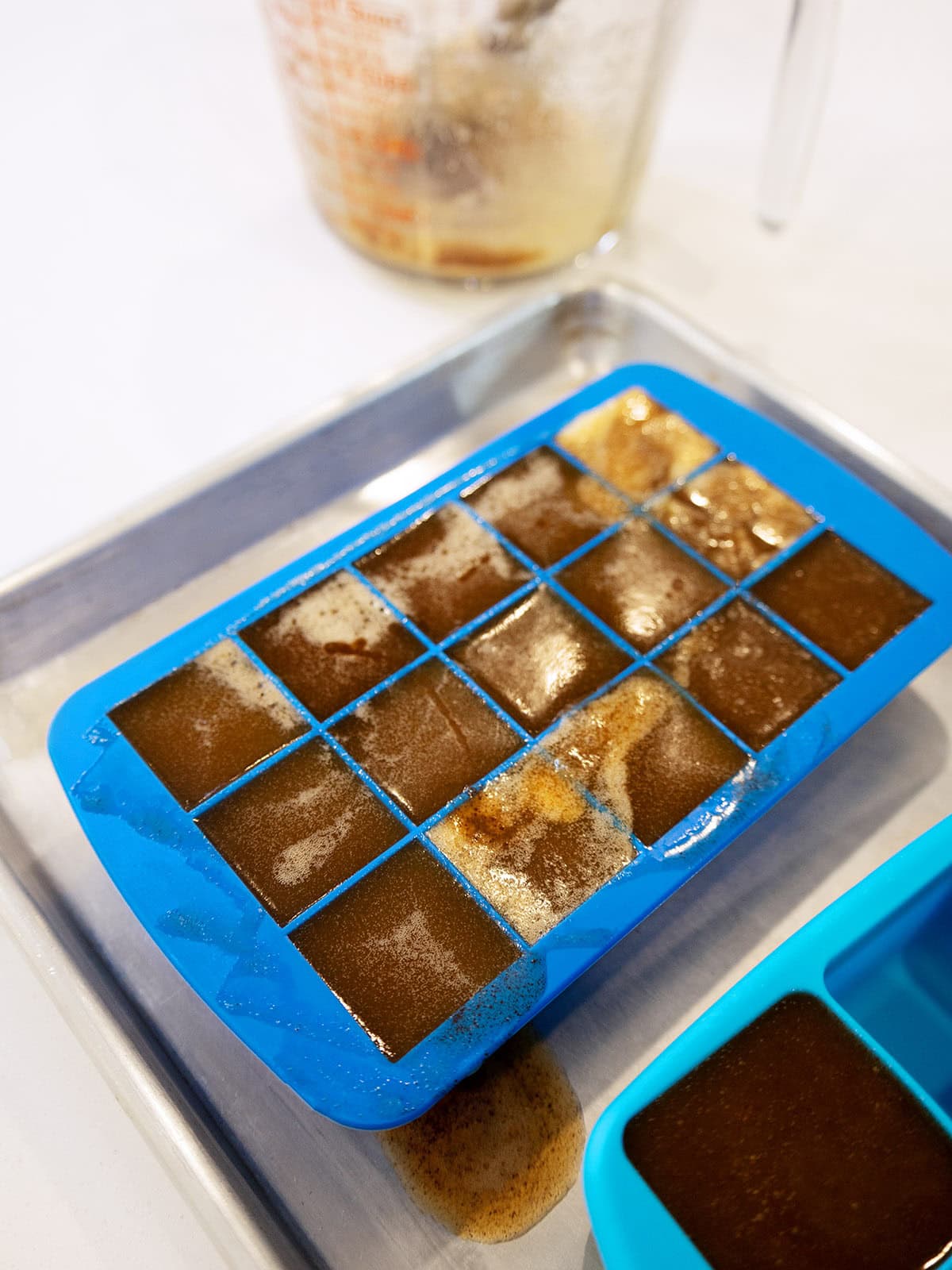 A silicone ice tray filled with frozen brown butter.
