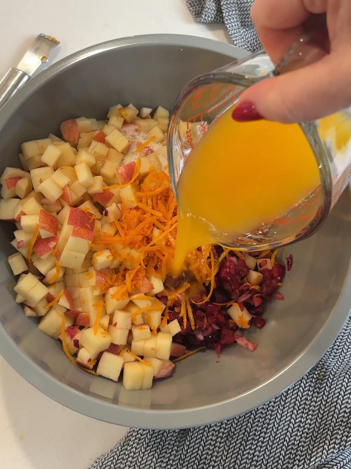 Adding orange juice to bowl of cranberry relish