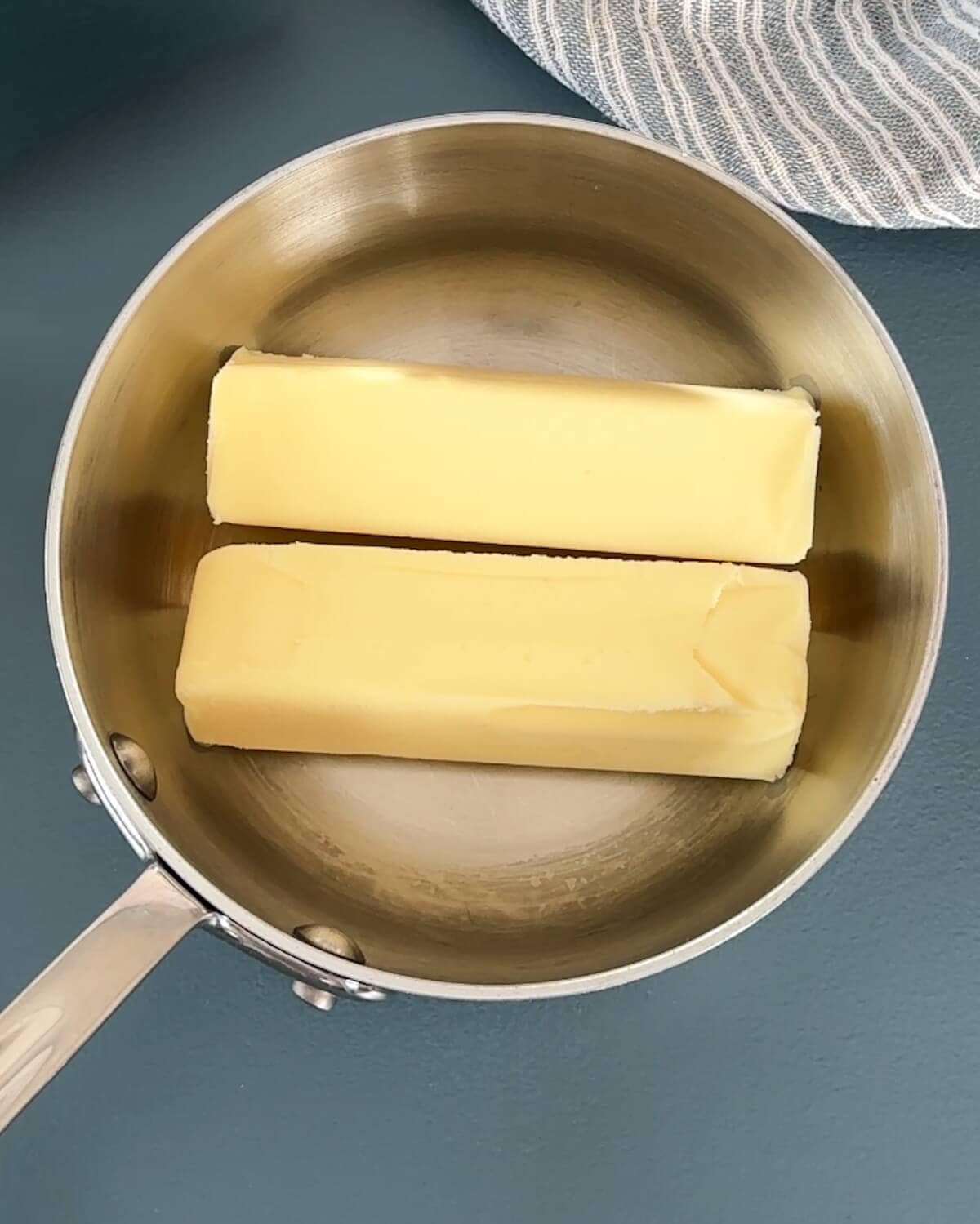 Two sticks of butter in a skillet.