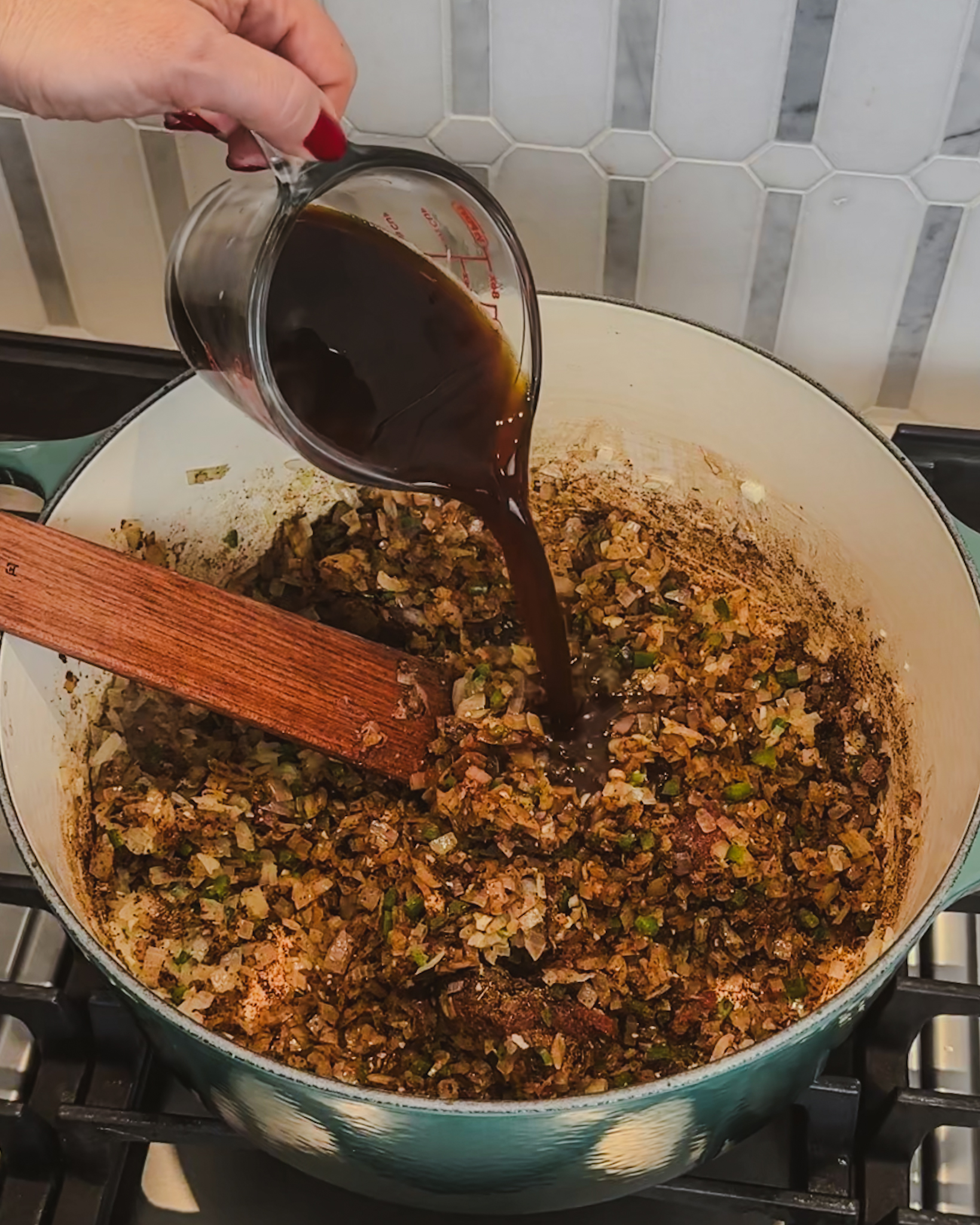 Adding brewed coffee to a post of aromatics and spices to add flavor to chili.