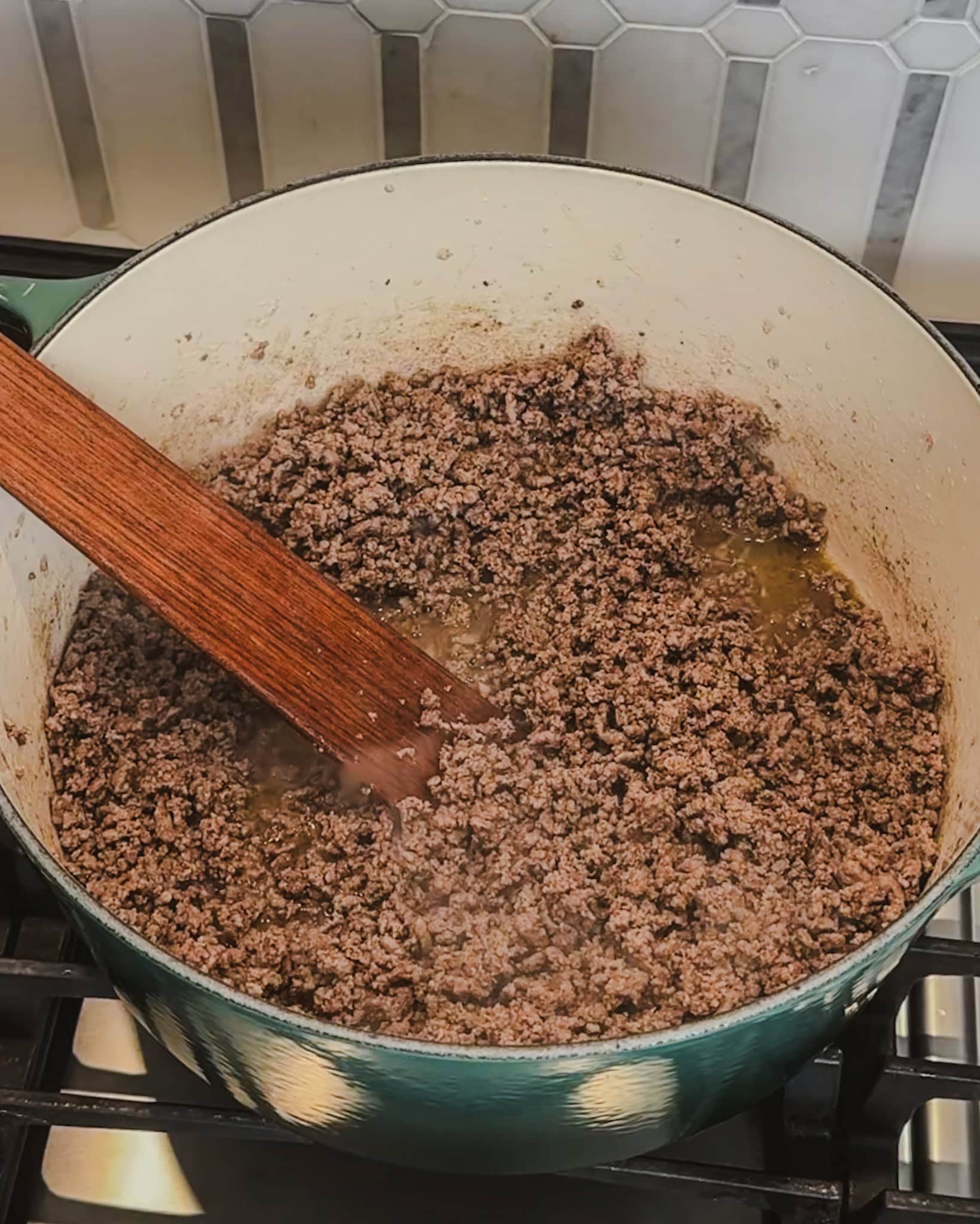 browned ground beef for chili in a large pot on the stove.