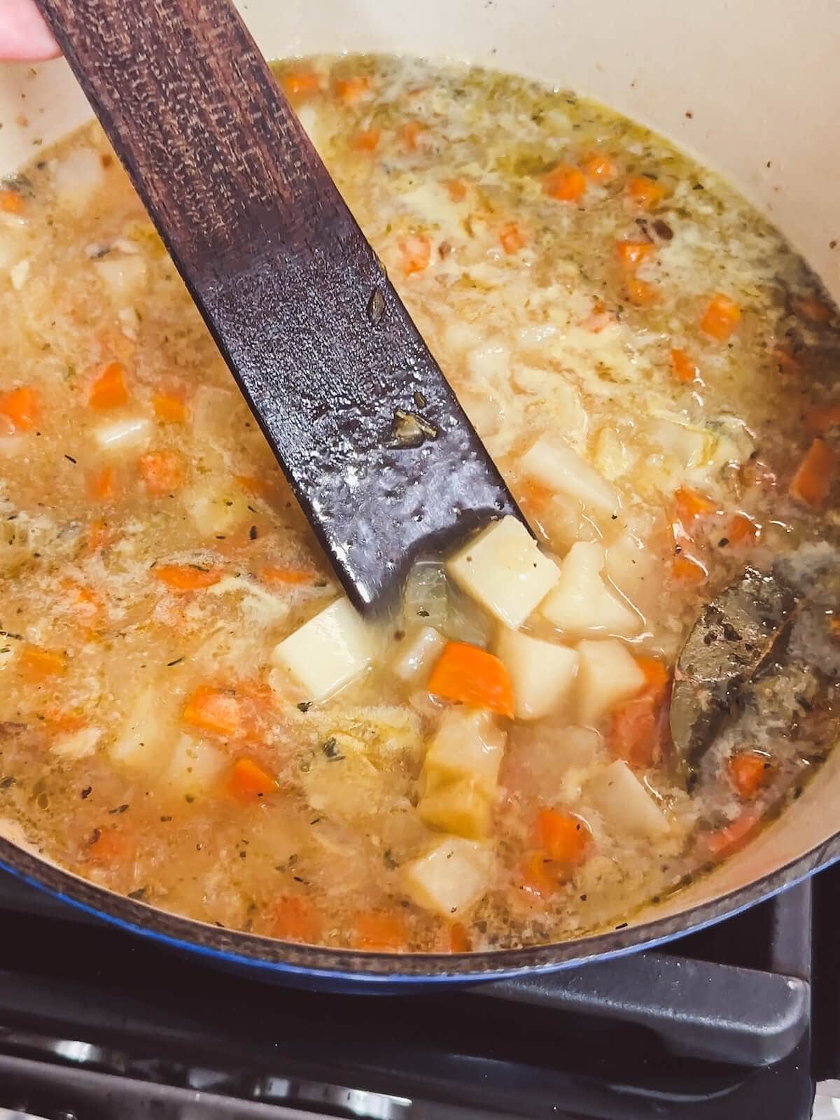 Stirring the bacon potato soup before adding cheese. 
