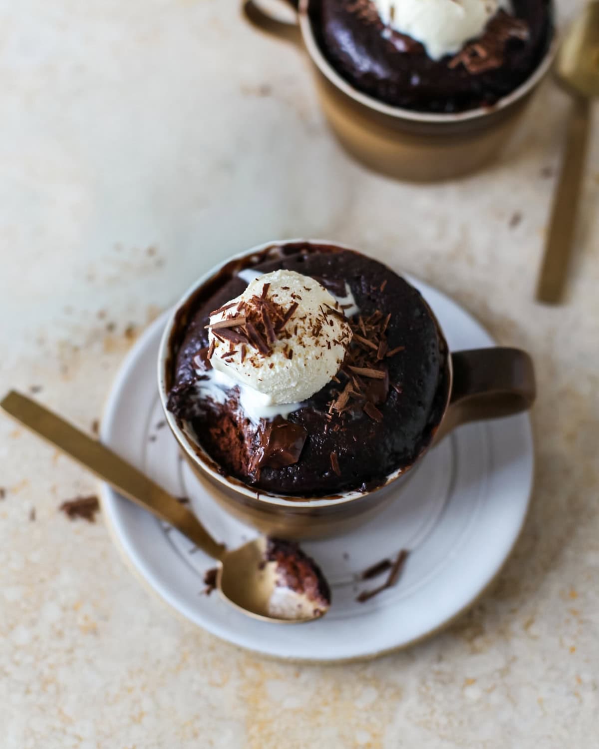 Top view of a chocolate mug cake with a bite removed on a spoon.