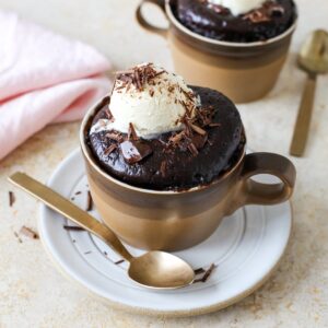 Close up of a chocolate mug cake next to a spoon.