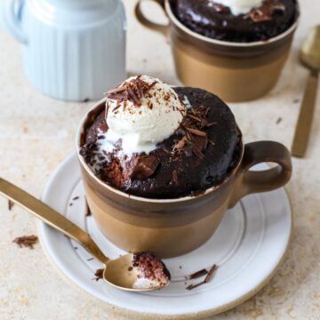 Close up of a chocolate mug cake with a bite removed on a spoon.