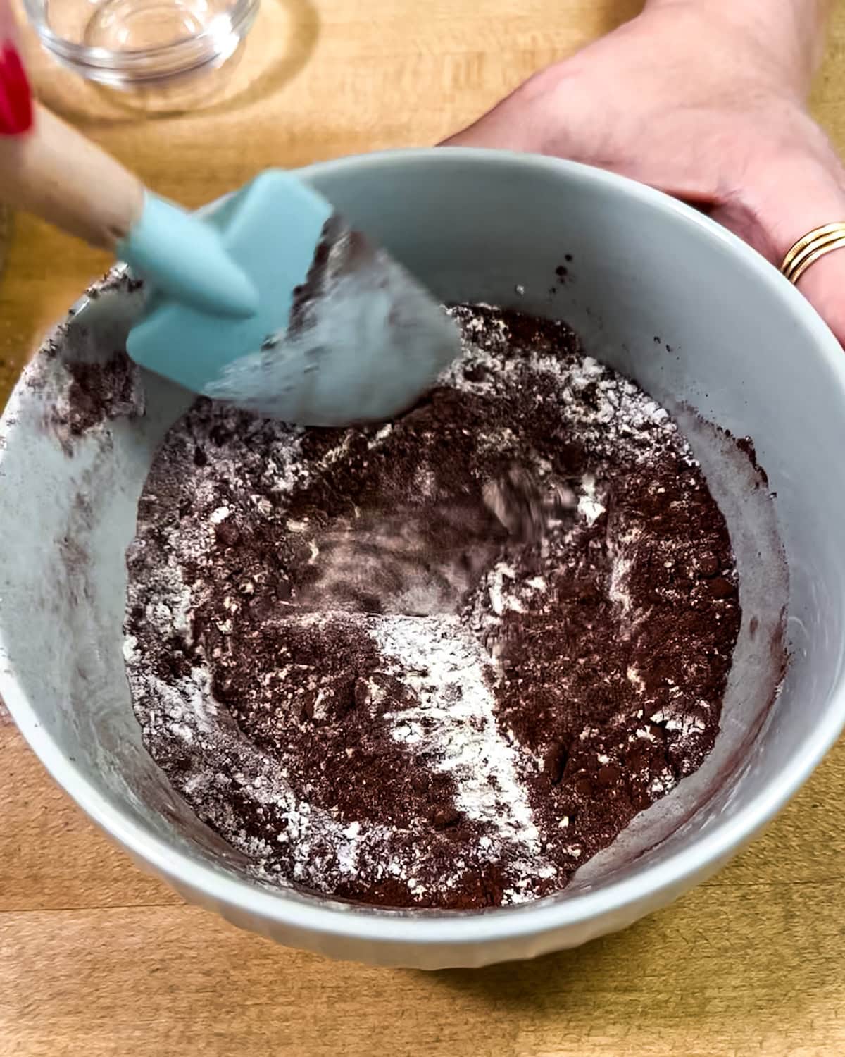 Dry ingredients being mixed together with a silicone spatula. 