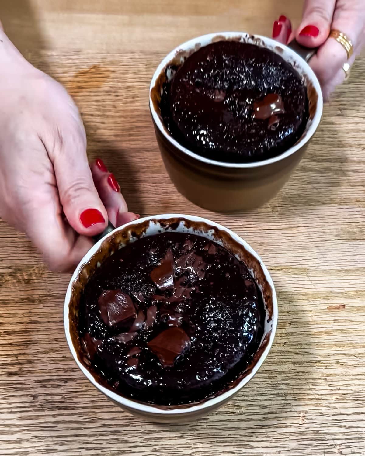 Top view of 2 baked chocolate mug cakes. 
