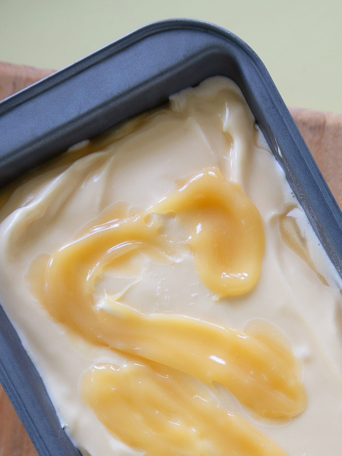 Top view of a loaf pan of lemon curd ice cream.