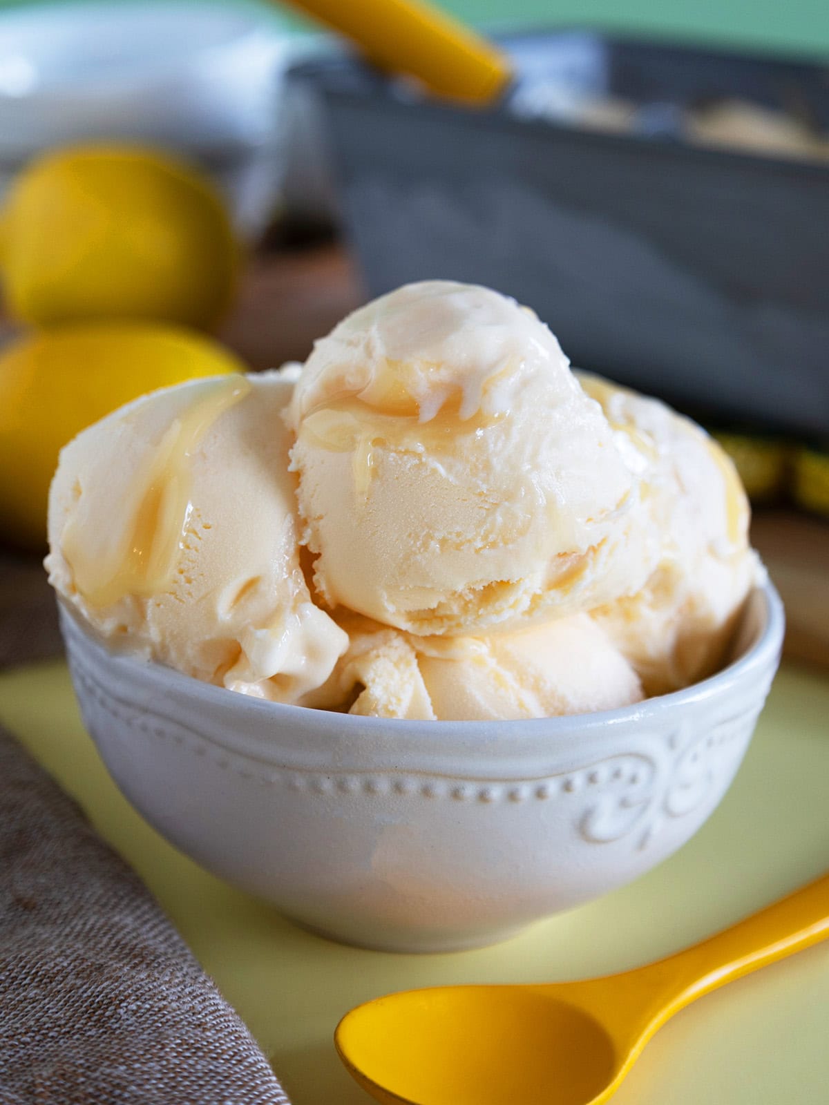 Close up of a bowl of lemon curd ice cream in a small white bowl.
